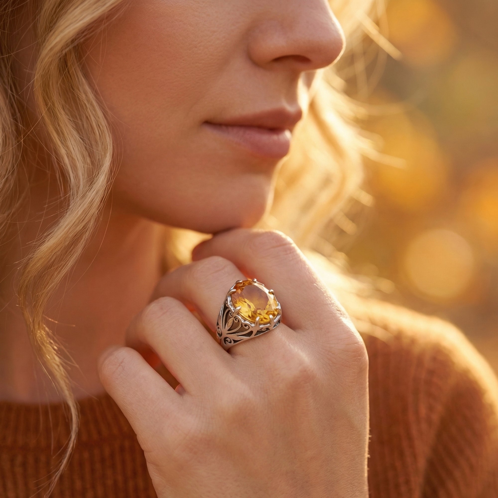 Profile view of the Solarielle sterling silver citrine statement ring worn on a model's hand in an outdoor setting.