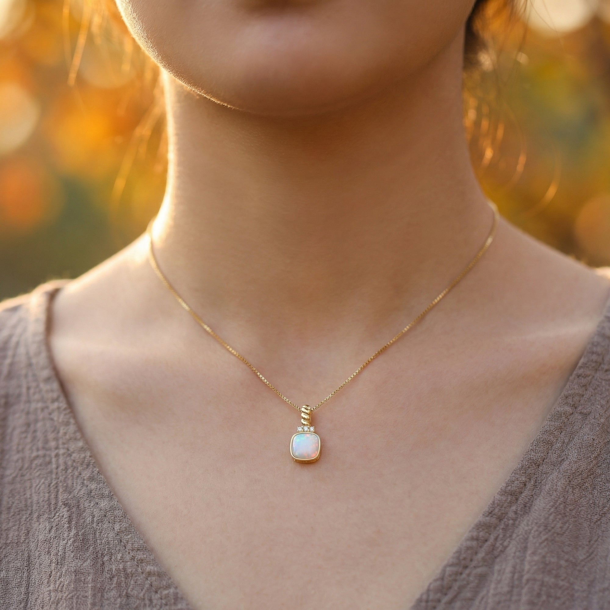 Front view of a model wearing the Soleil white opal cushion pendant necklace in gold-tone silver.