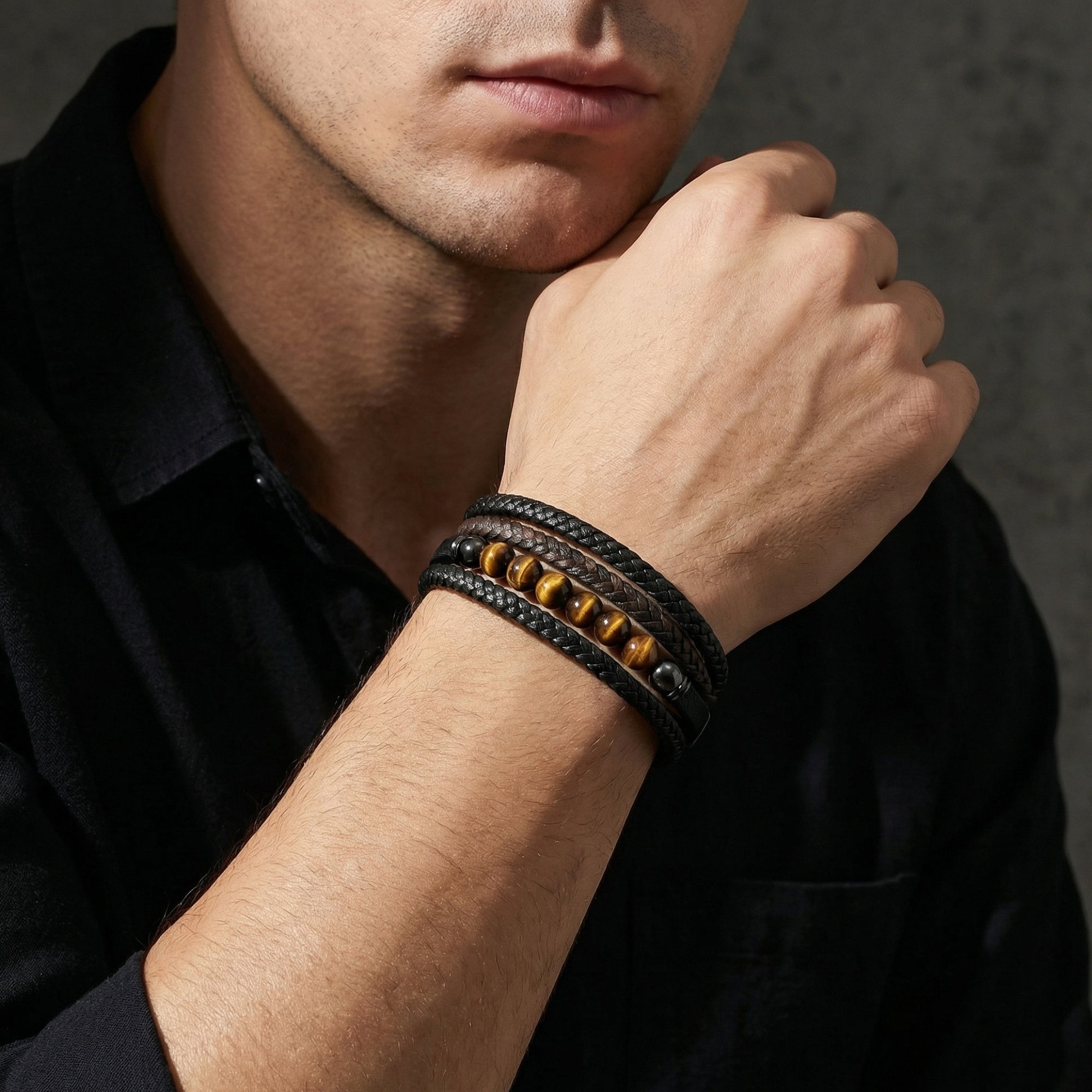 Model wearing the Garrison black braided leather bracelet with tiger's eye stones and black hardware.