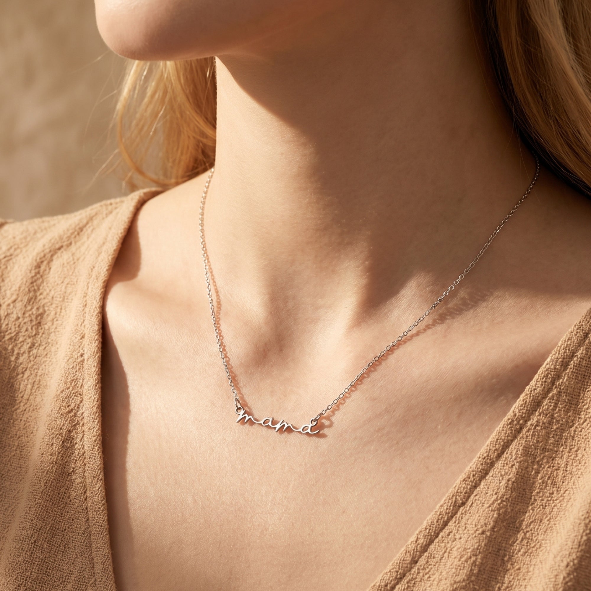 Silver mama script necklace worn by a model.