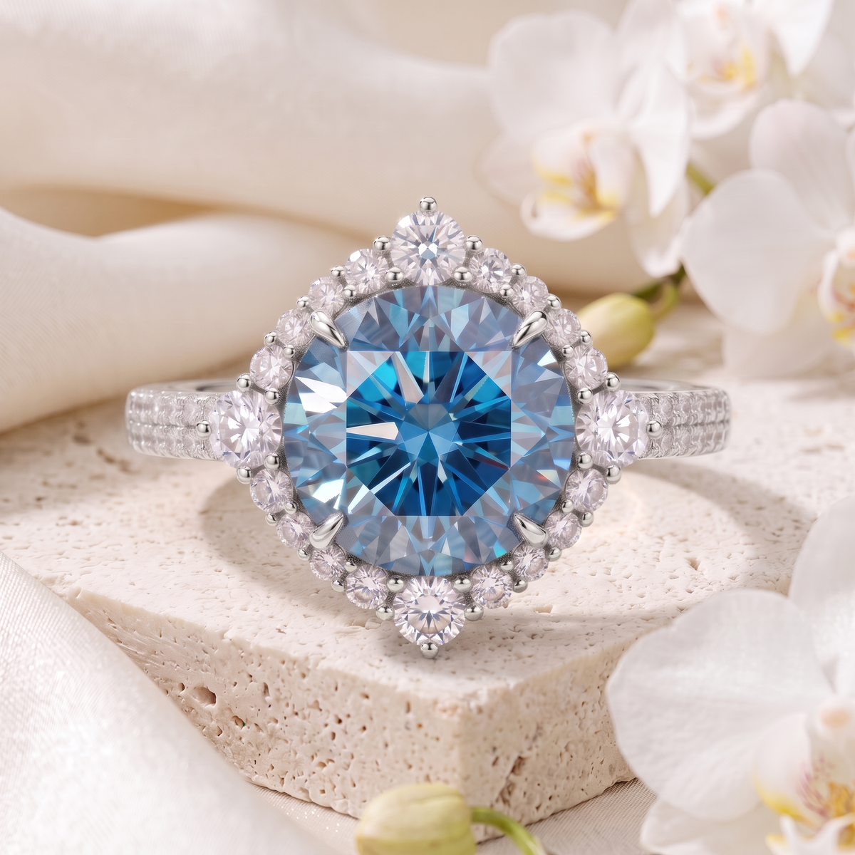Round blue moissanite halo engagement ring in white gold on a stone display.