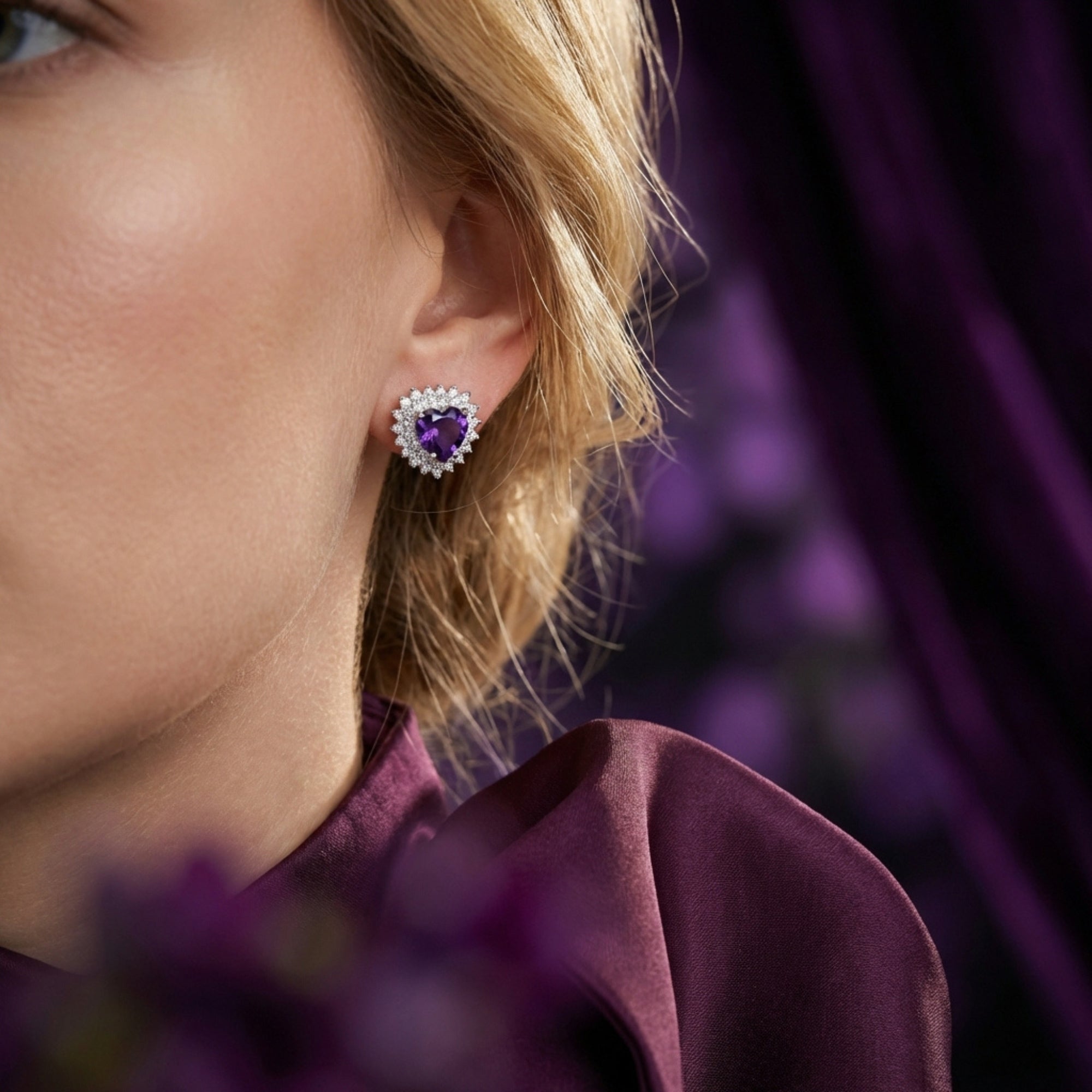 A model wearing the heart cut amethyst earrings in sterling silver, highlighting the deep violet gemstone color.