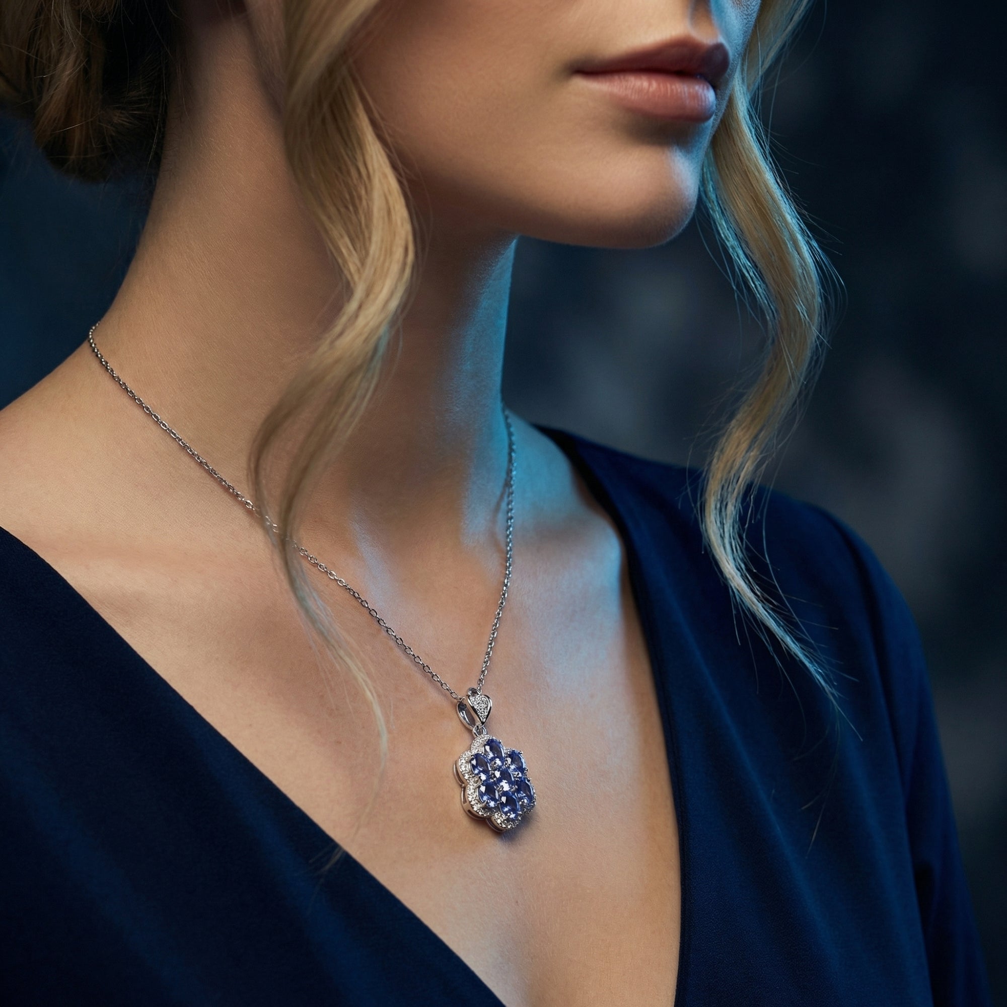 Lifestyle view of a woman wearing the white gold Caelestia necklace with a cluster of oval blue tanzanite.