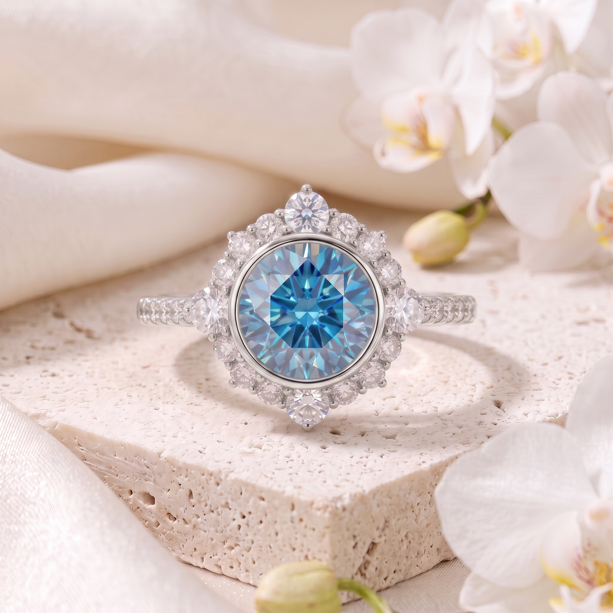 Round blue moissanite halo engagement ring in white gold resting on a stone display.