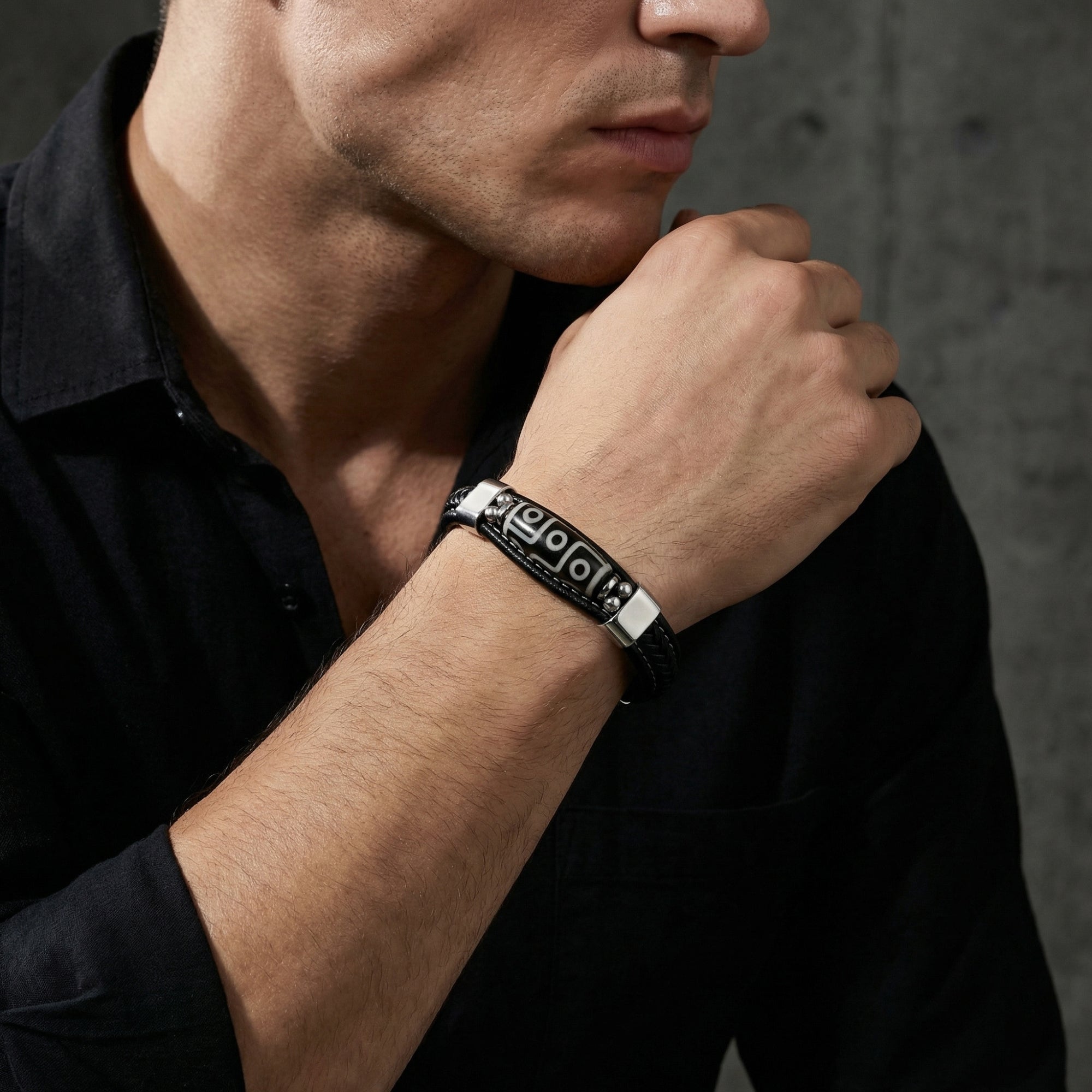 Model wearing the Echelon men's braided leather bracelet with silver stainless steel accents and black shirt.