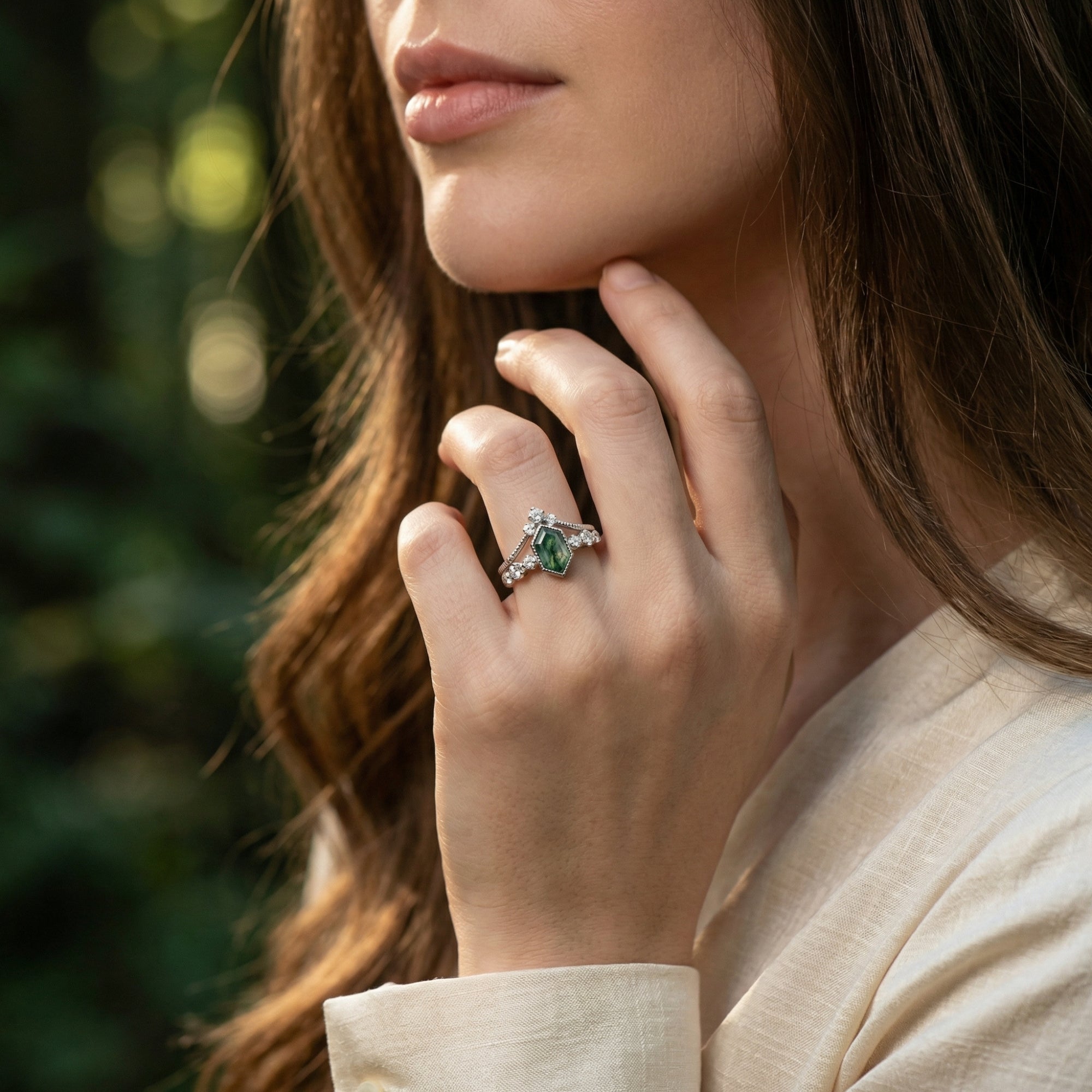 Sterling silver kite cut moss agate ring duo worn by a model in a natural outdoor setting.