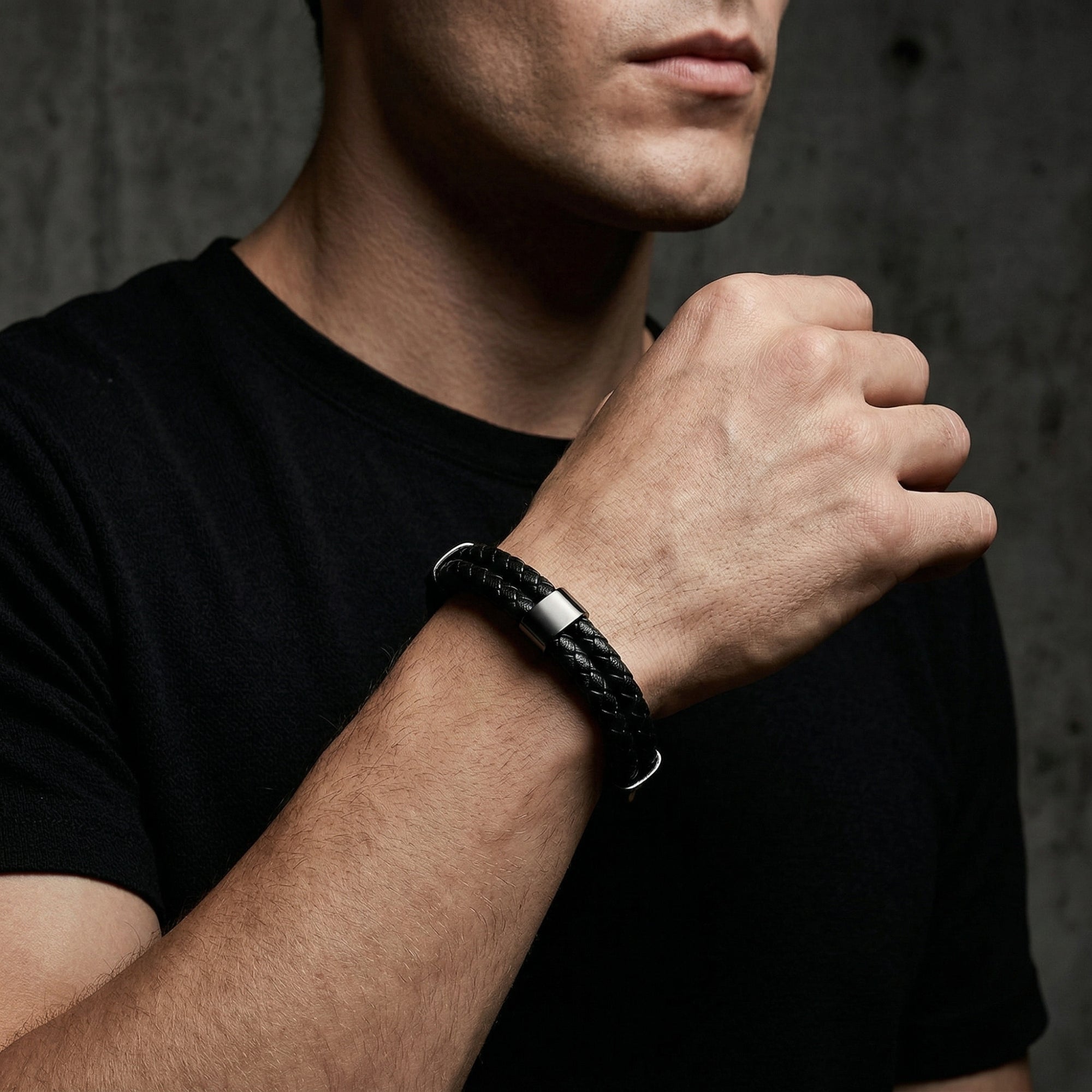 Black double-braided leather bracelet with a black stainless steel magnetic clasp shown on a man's wrist.