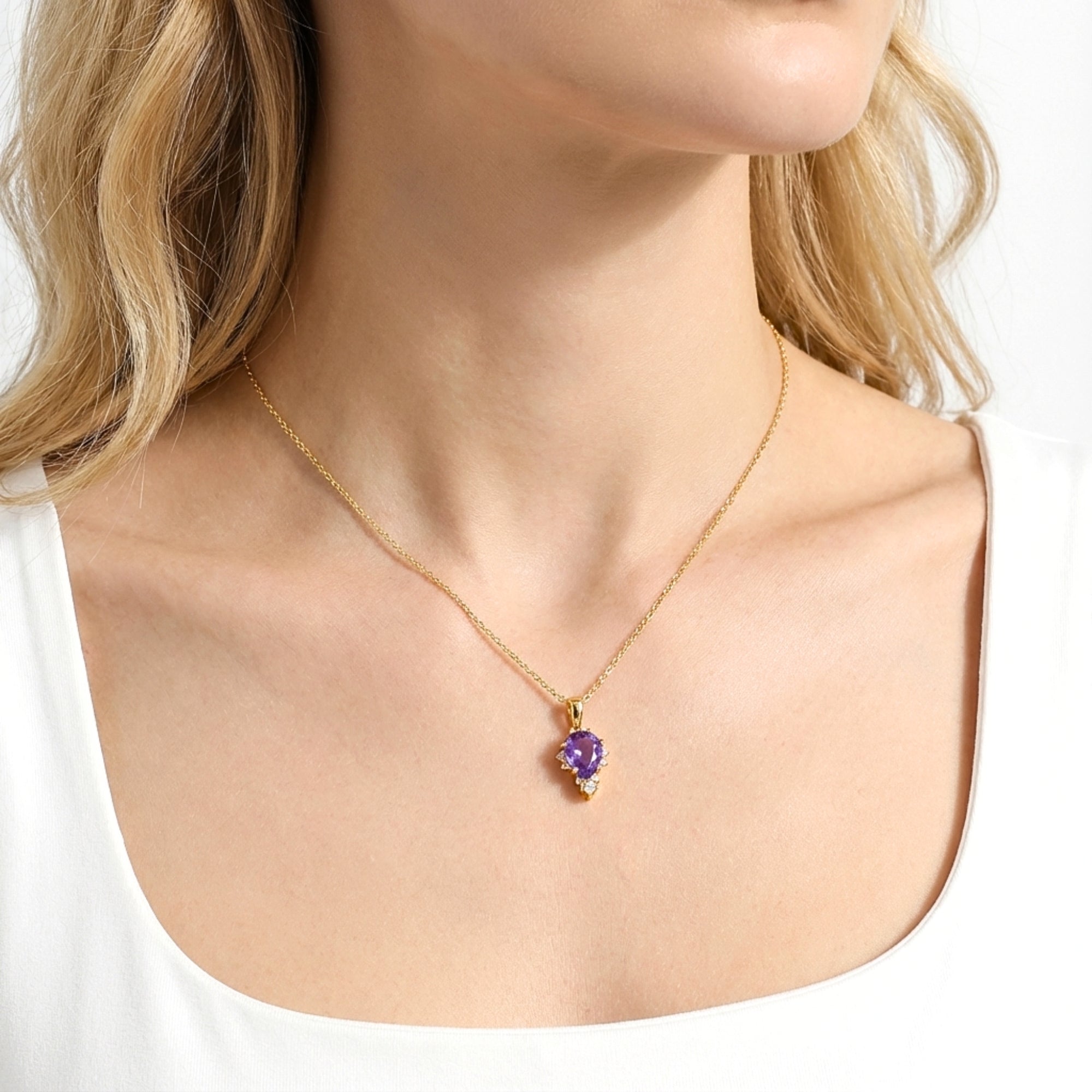 Model wearing the Eudora Drop 18K gold vermeil necklace with a pear cut simulated amethyst.