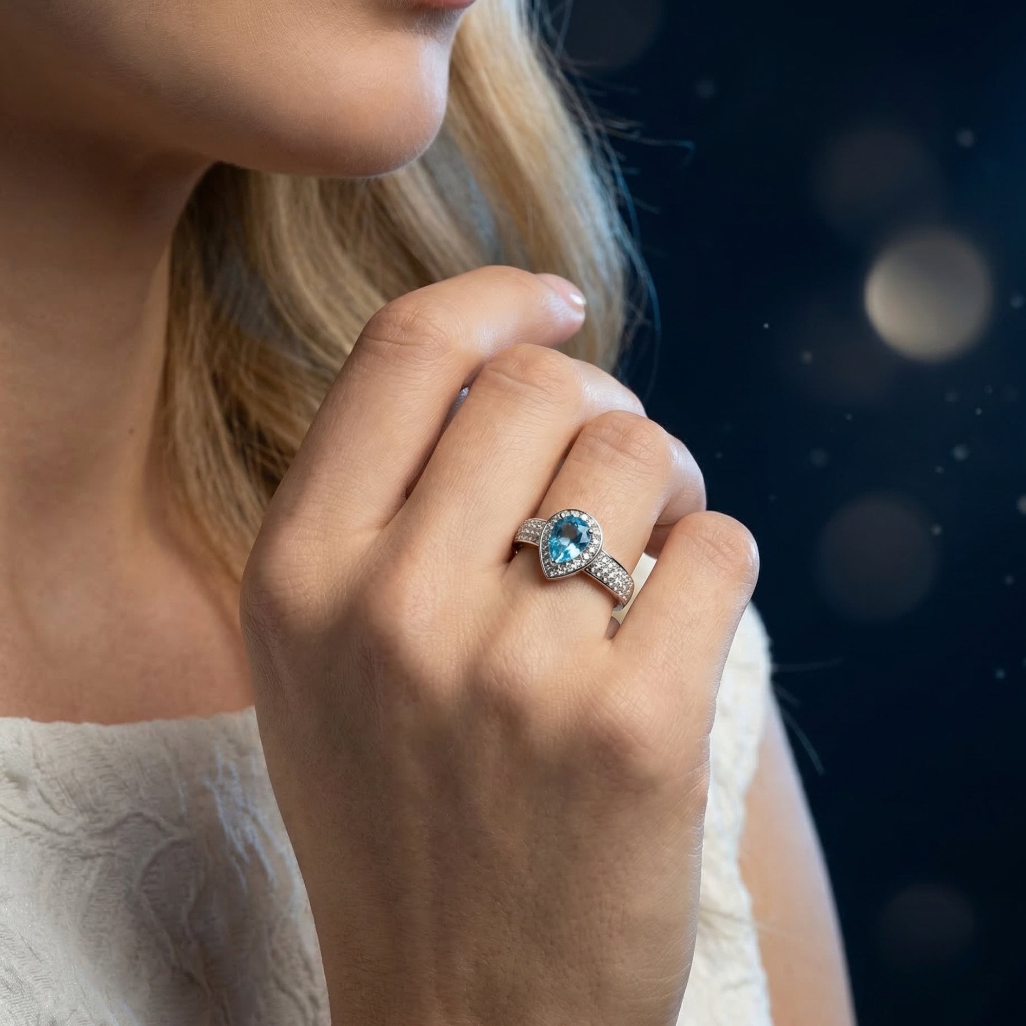 Model wearing the Mariana Swiss blue topaz ring in sterling silver, showcasing the pear cut gemstone.