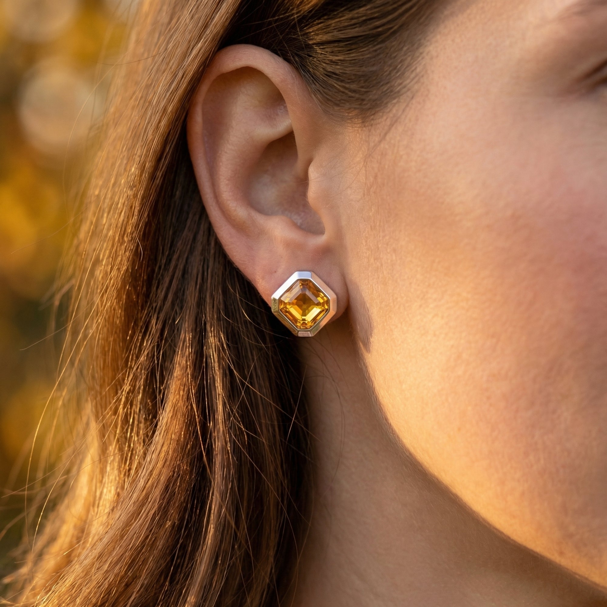 A model wearing the Leonie natural citrine white gold earring, highlighting the vibrant golden color against the skin.