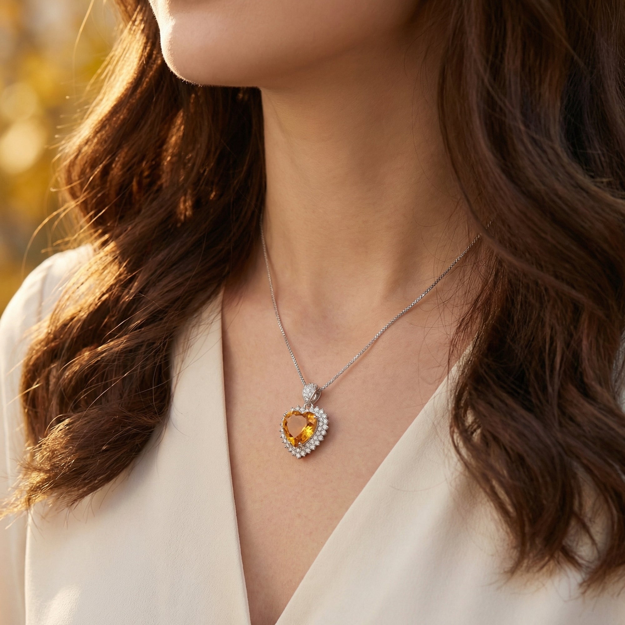 Heart cut citrine halo necklace in sterling silver worn by a model, capturing the warmth of the golden hour.