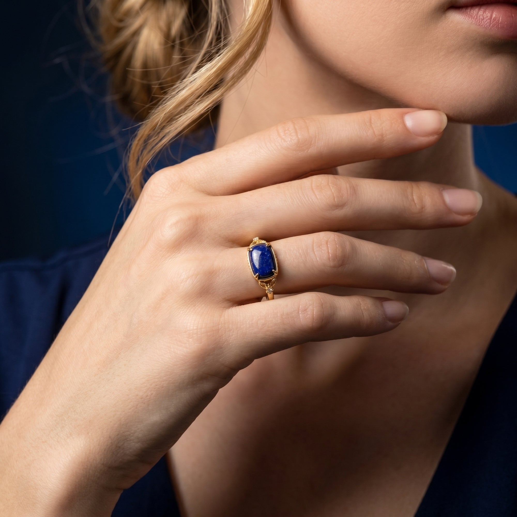 Yellow gold Alexandria natural lapis ring worn by a model, showcasing the deep blue stone against a dark blue dress.