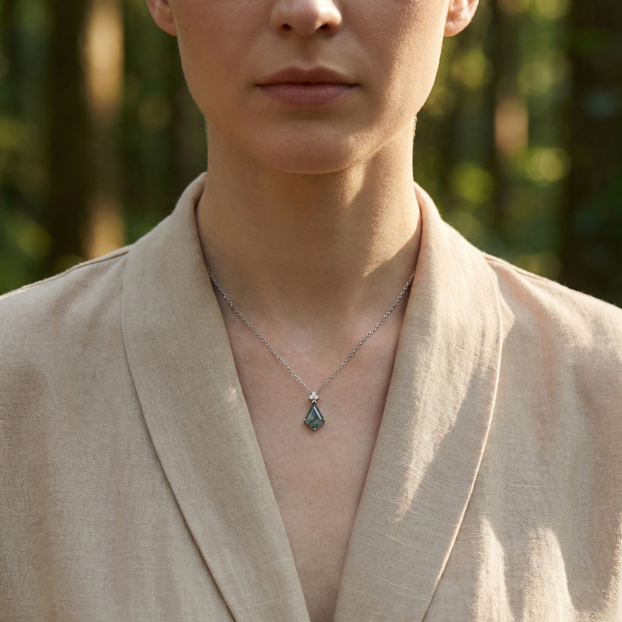 Front view of a model wearing the kite cut natural moss agate sterling silver necklace.