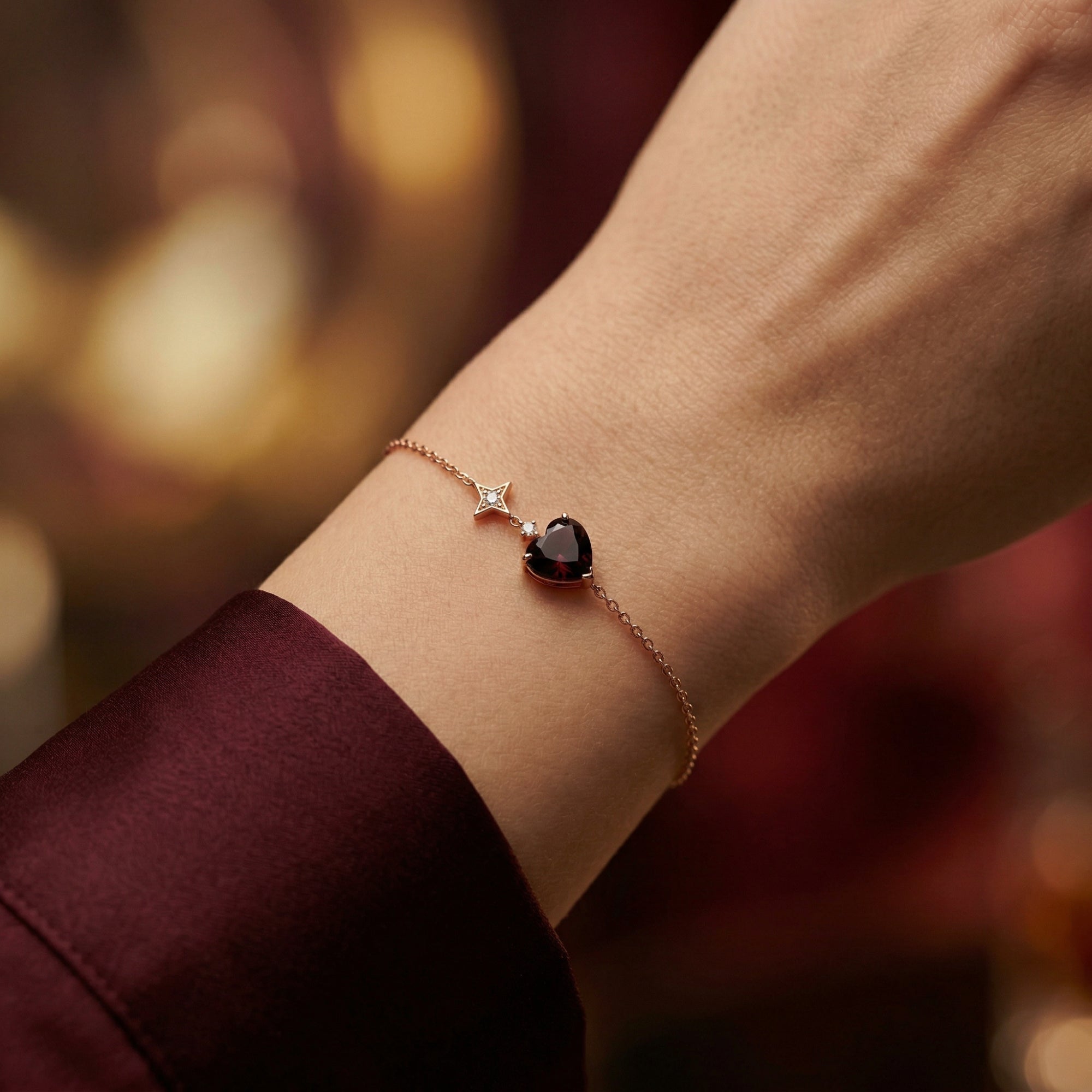 Close-up of the 18K rose gold heart-cut garnet bracelet on a model's wrist.