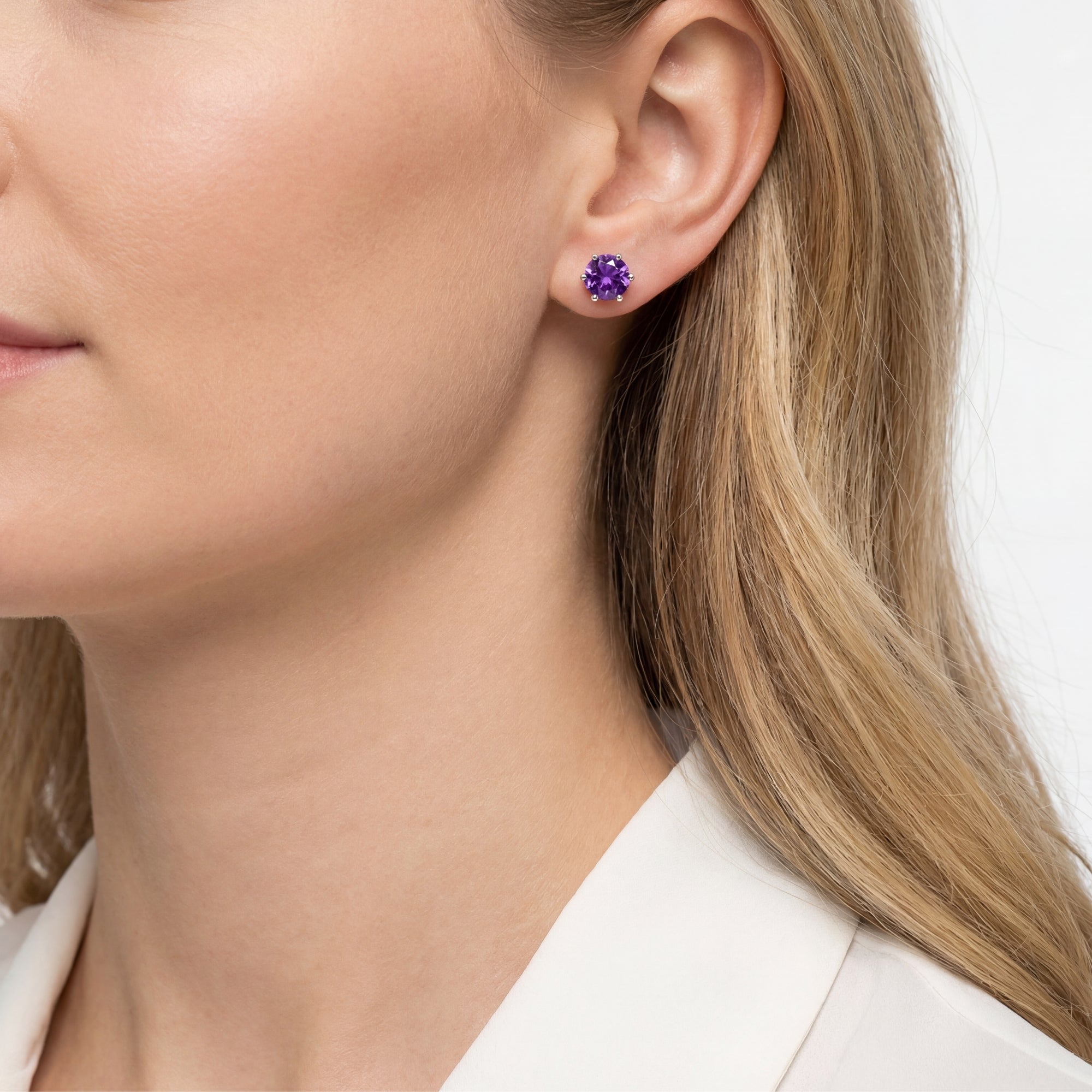 Side view of a model wearing a round cut simulated amethyst sterling silver stud earring.