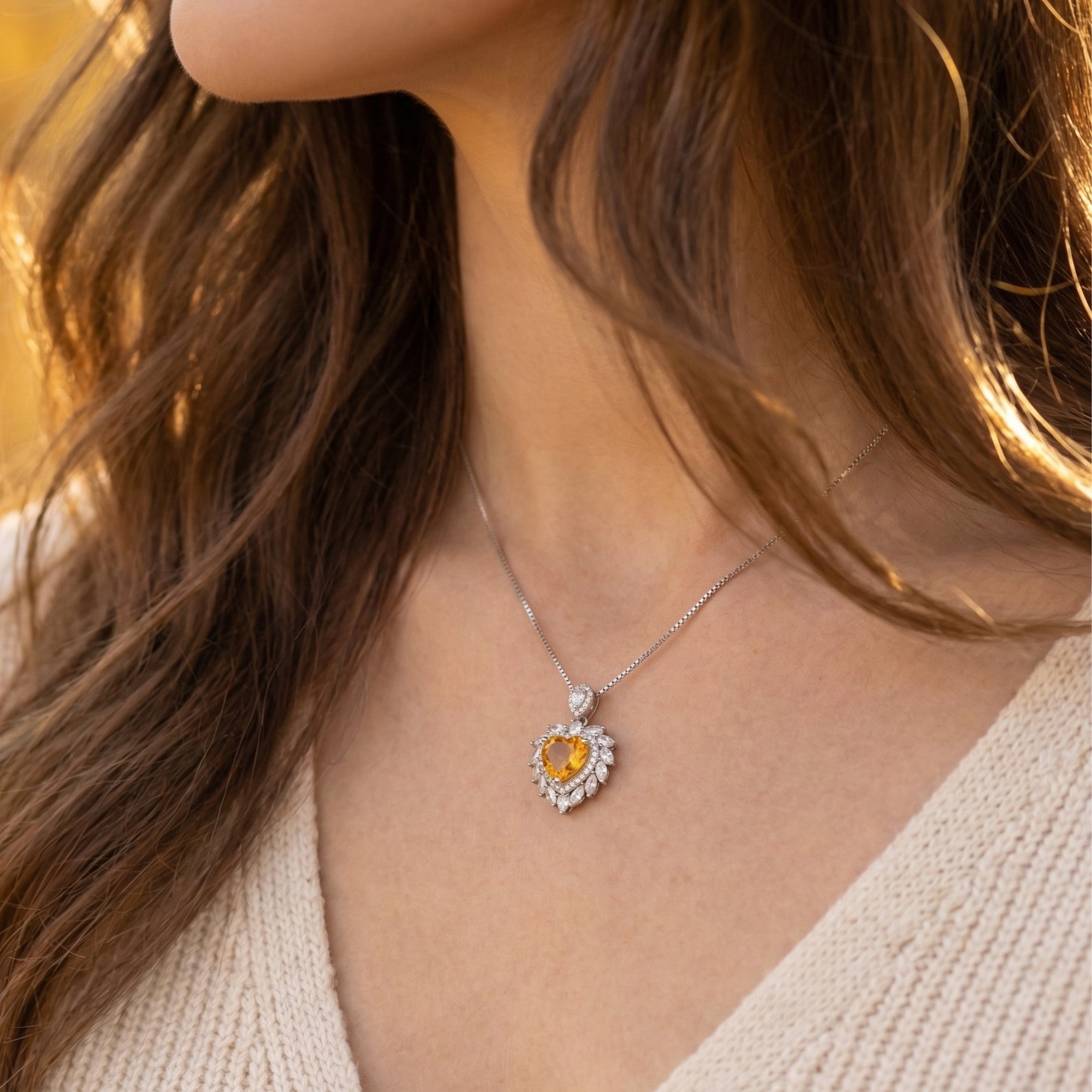 Model wearing the heart cut citrine pendant on a silver chain, showing the jewelry's scale and glow.