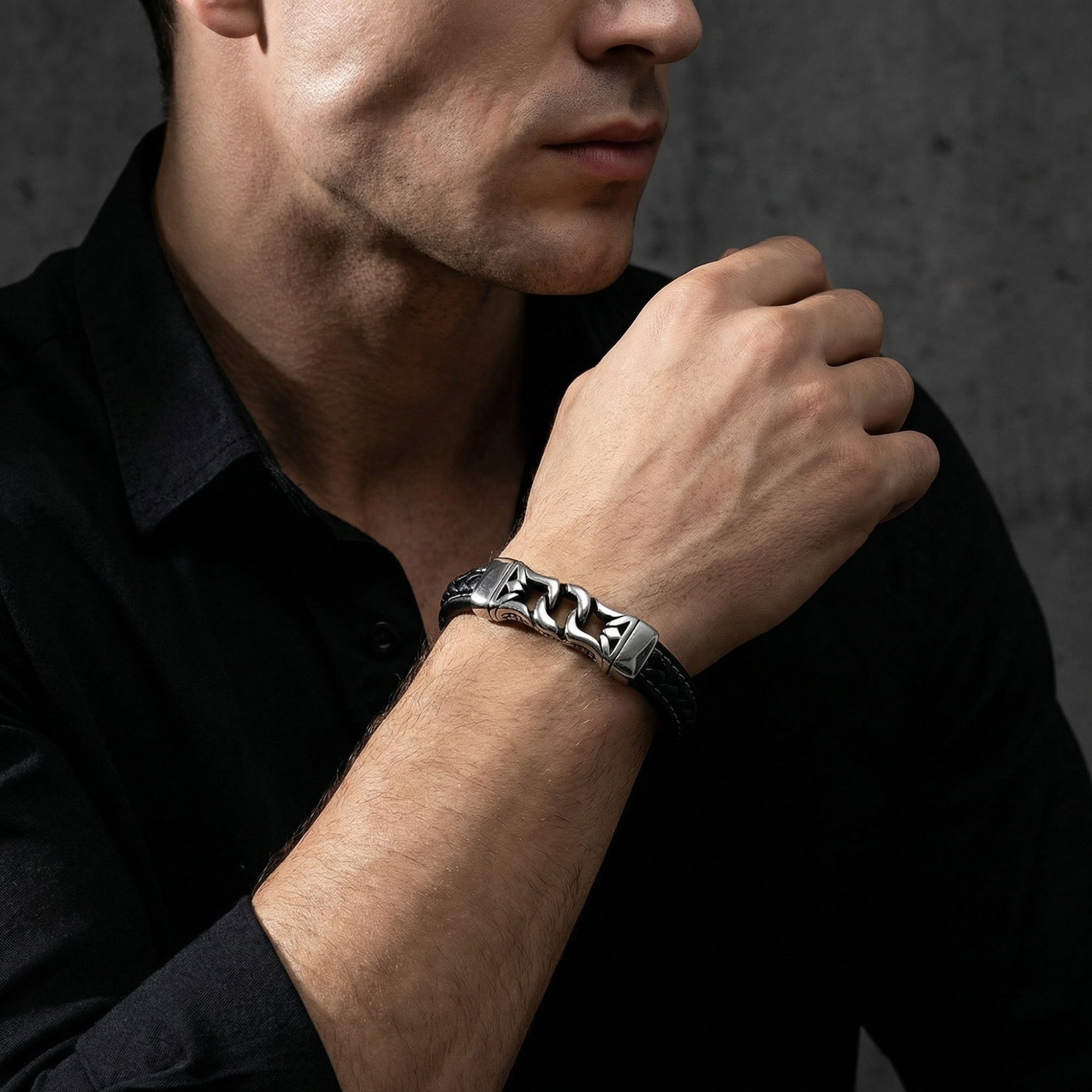 Silver stainless steel and black braided leather Nexus Bracelet for men styled on a model's wrist.