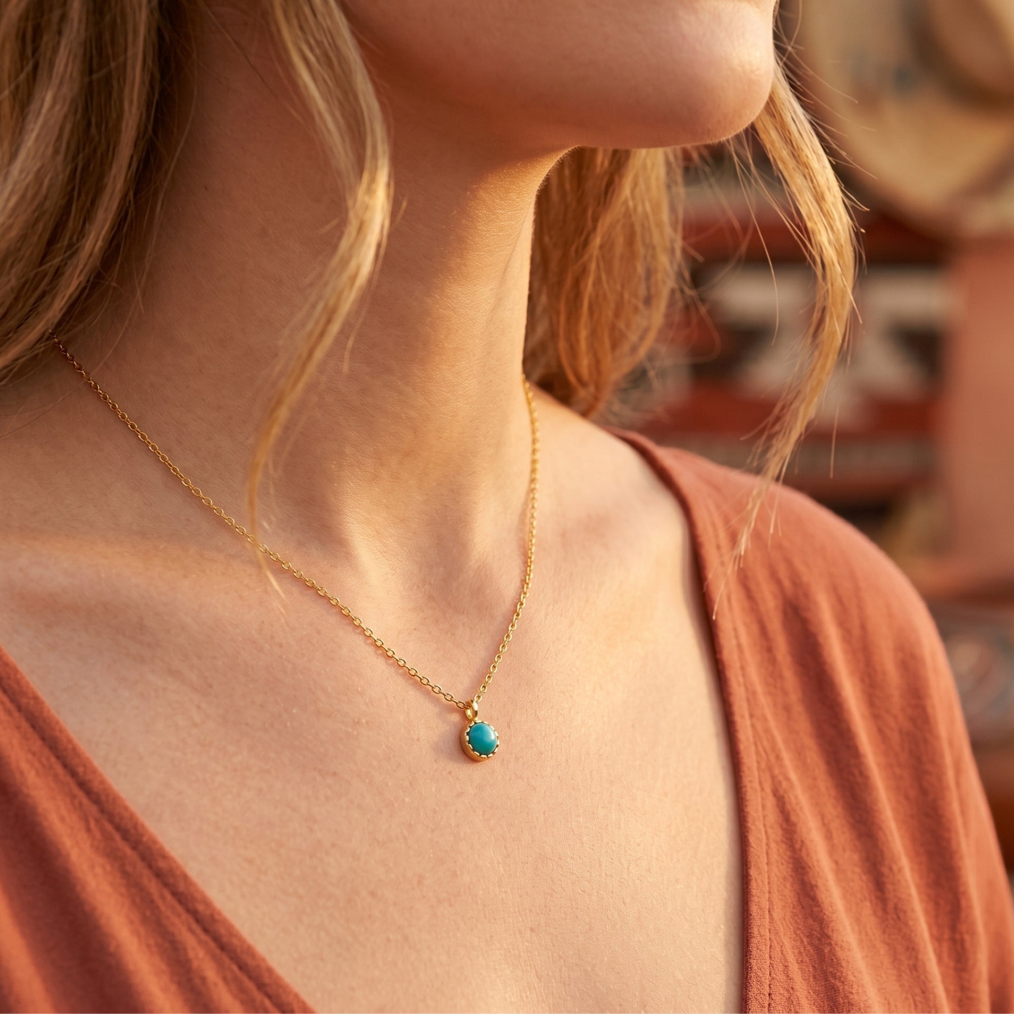 Close-up of the gold vermeil turquoise necklace worn by a model, highlighting the round cabochon stone and delicate chain.