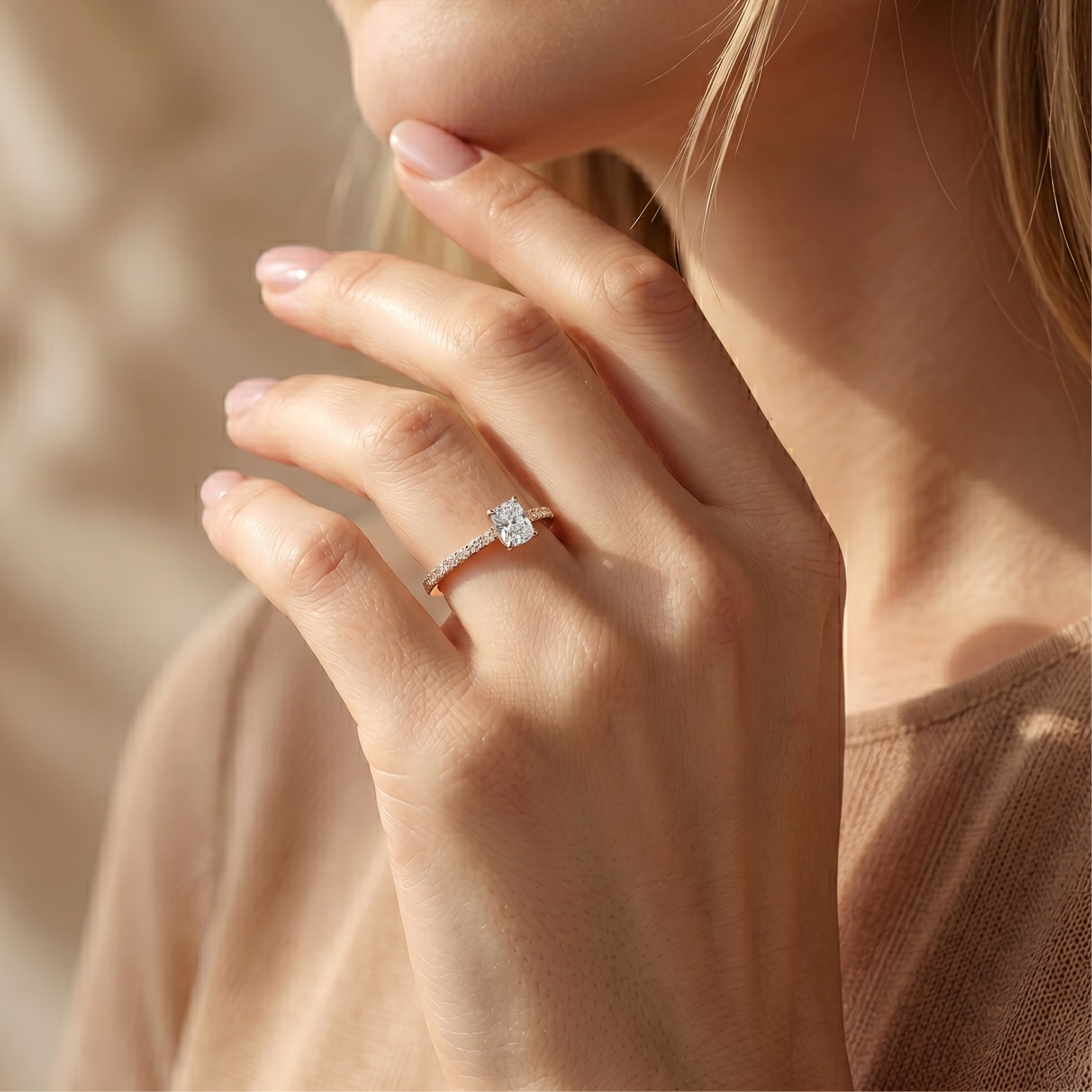 Close-up of a model wearing a cushion-cut yellow gold moissanite engagement ring.