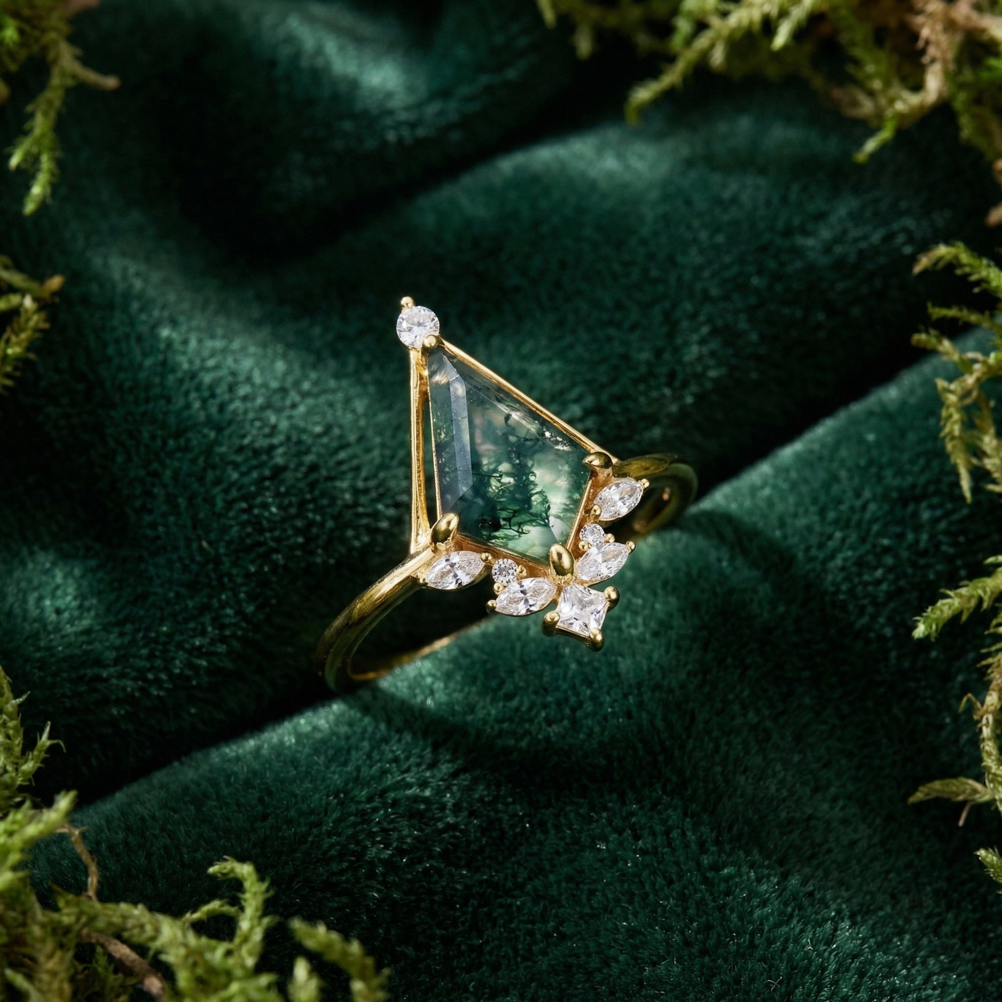Kite-cut moss agate ring in gold-plated sterling silver with diamond accents displayed on a mossy background.