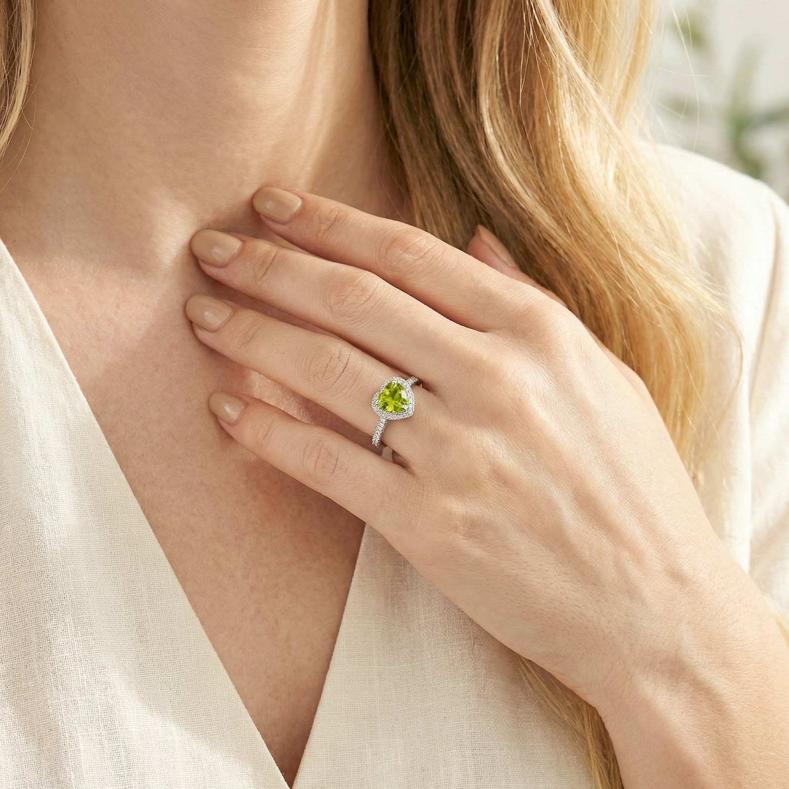 Close-up of a model wearing the S925 sterling silver heart-cut simulated peridot ring on her hand.