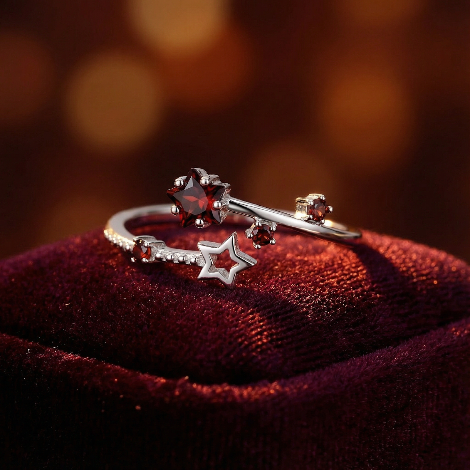 Sterling silver Sidereal Star Ring with star-cut simulated garnet on a red velvet background.
