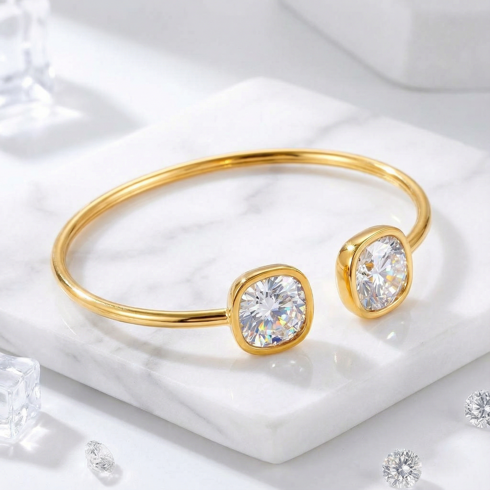 Gold-tone stainless steel cuff bracelet with cushion-cut moissanite stones on a white marble surface.