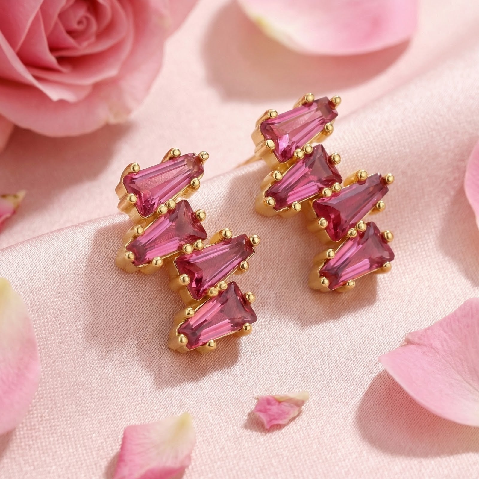 Thalissa Cascade gold vermeil earrings with pink tourmaline baguette stones on pink silk with rose petals.