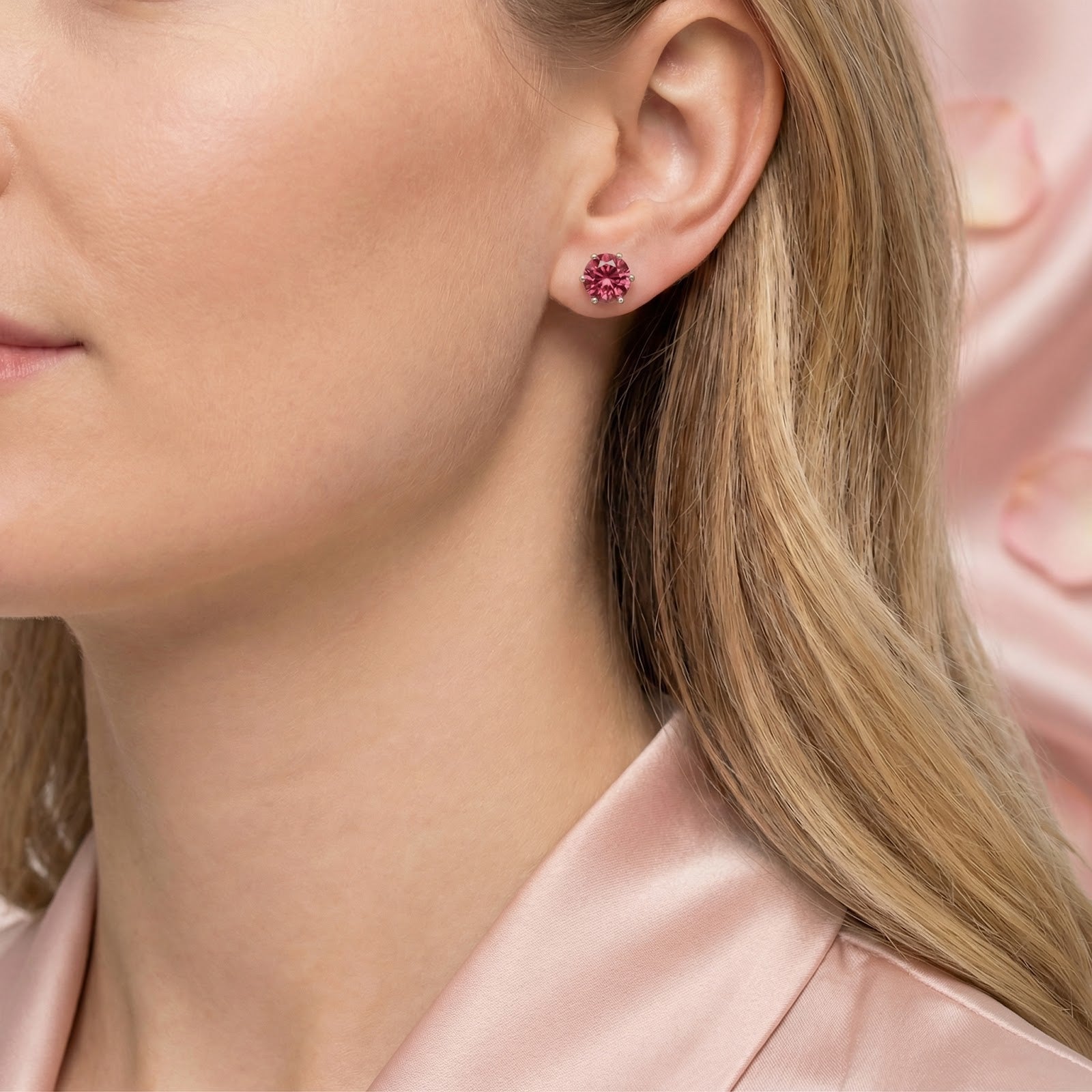 Side view of a model wearing a 6.5mm round simulated pink tourmaline sterling silver stud earring.