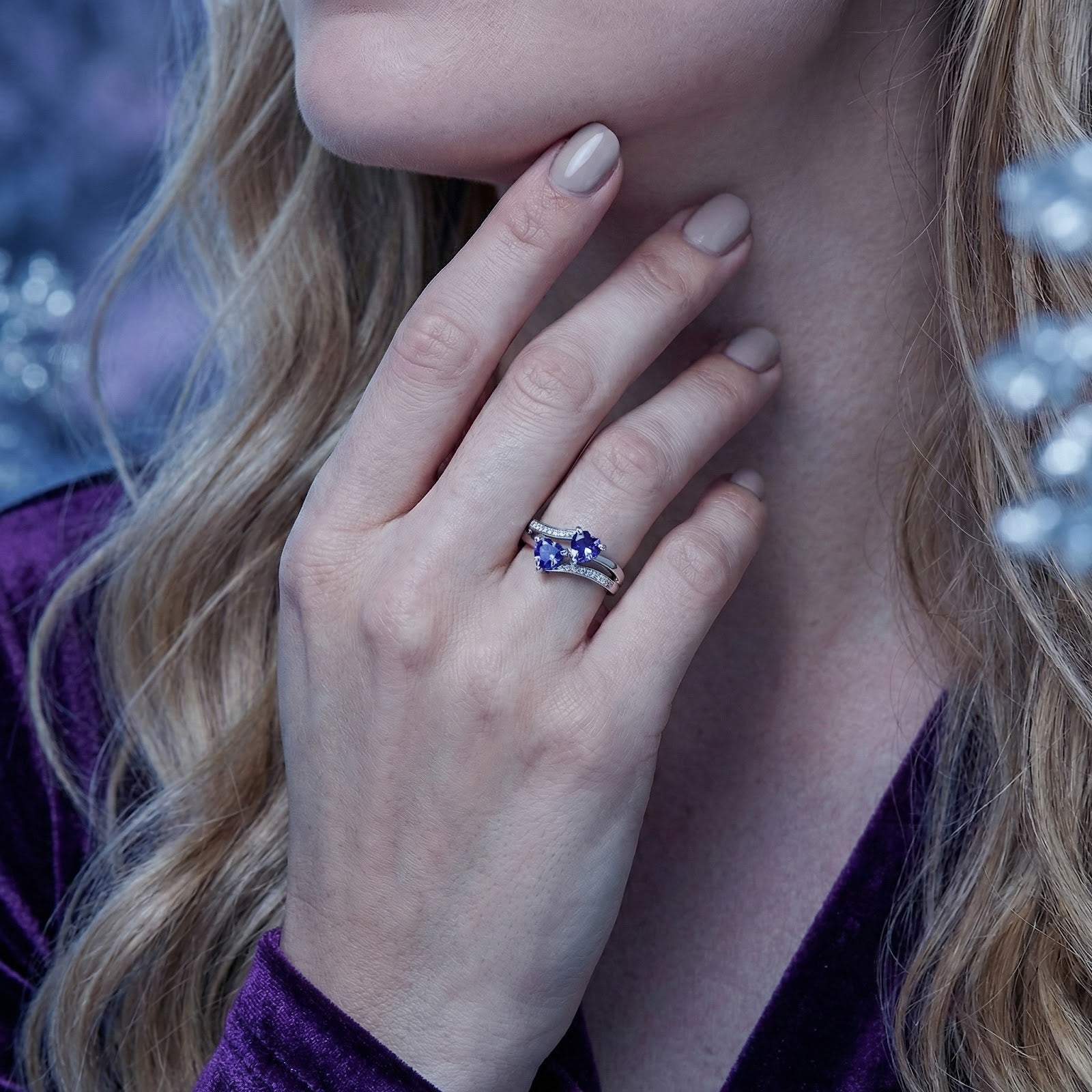 Close-up of the S925 sterling silver heart ring with blue simulated tanzanite stones worn on a model's finger.