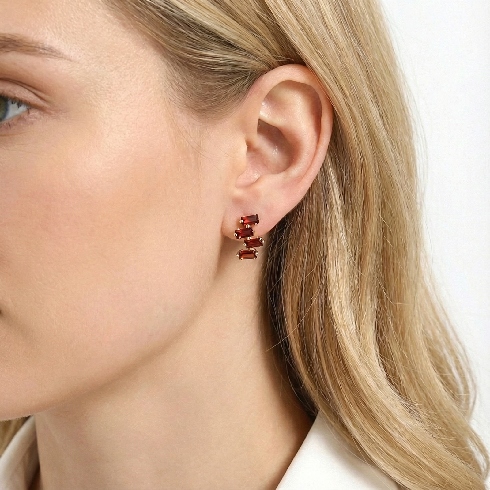 Close-up of the red simulated garnet cluster earring in 18K gold vermeil on a model's ear.