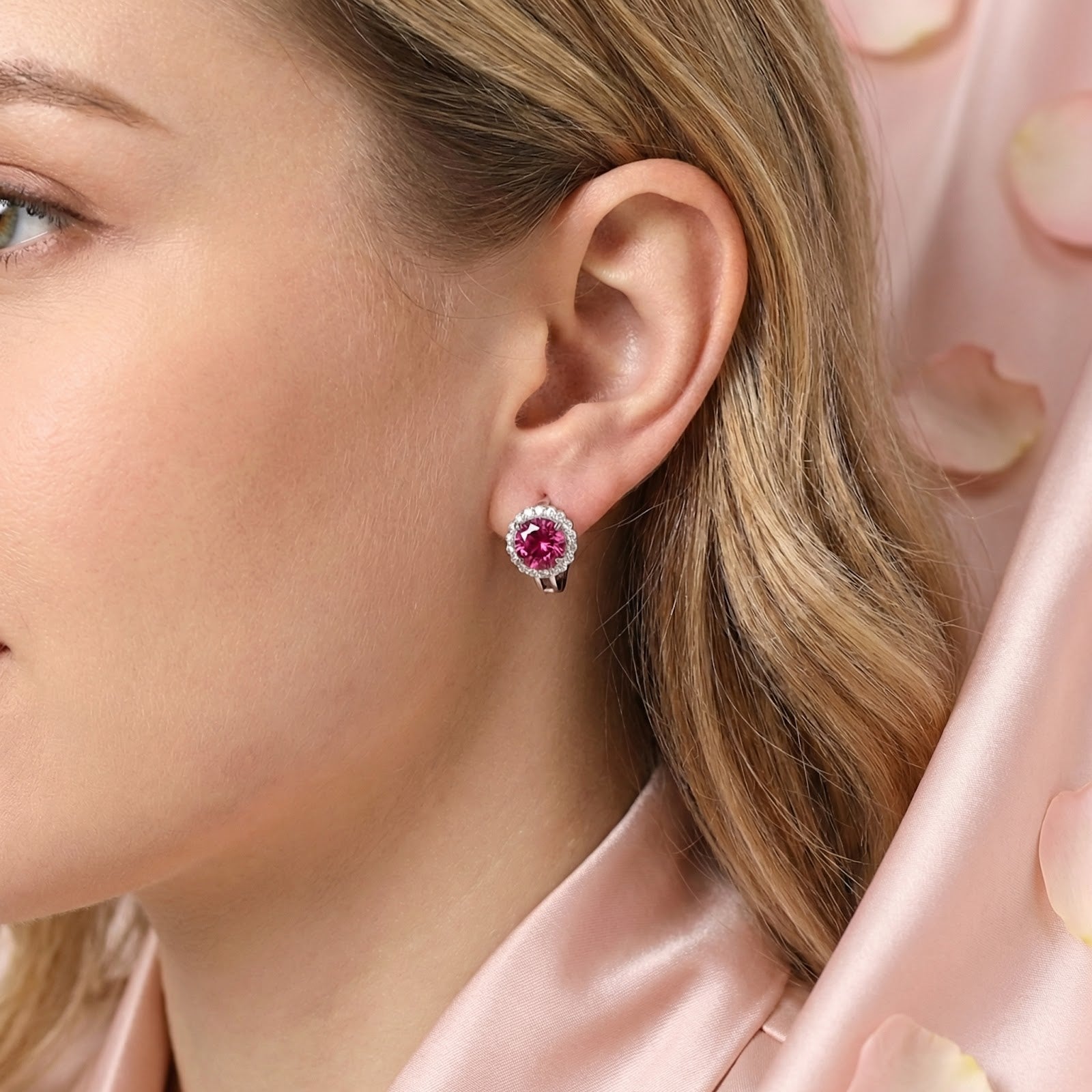 Side view of a woman wearing a pink moissanite halo stud earring in sterling silver.