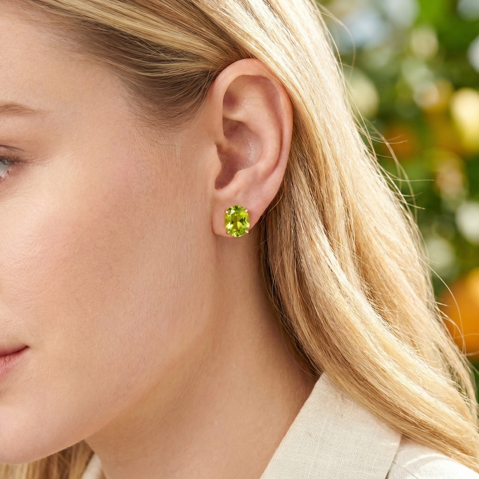 Close-up of the Verdelle August birthstone simulated peridot cabochon stud earring worn on a model's ear.