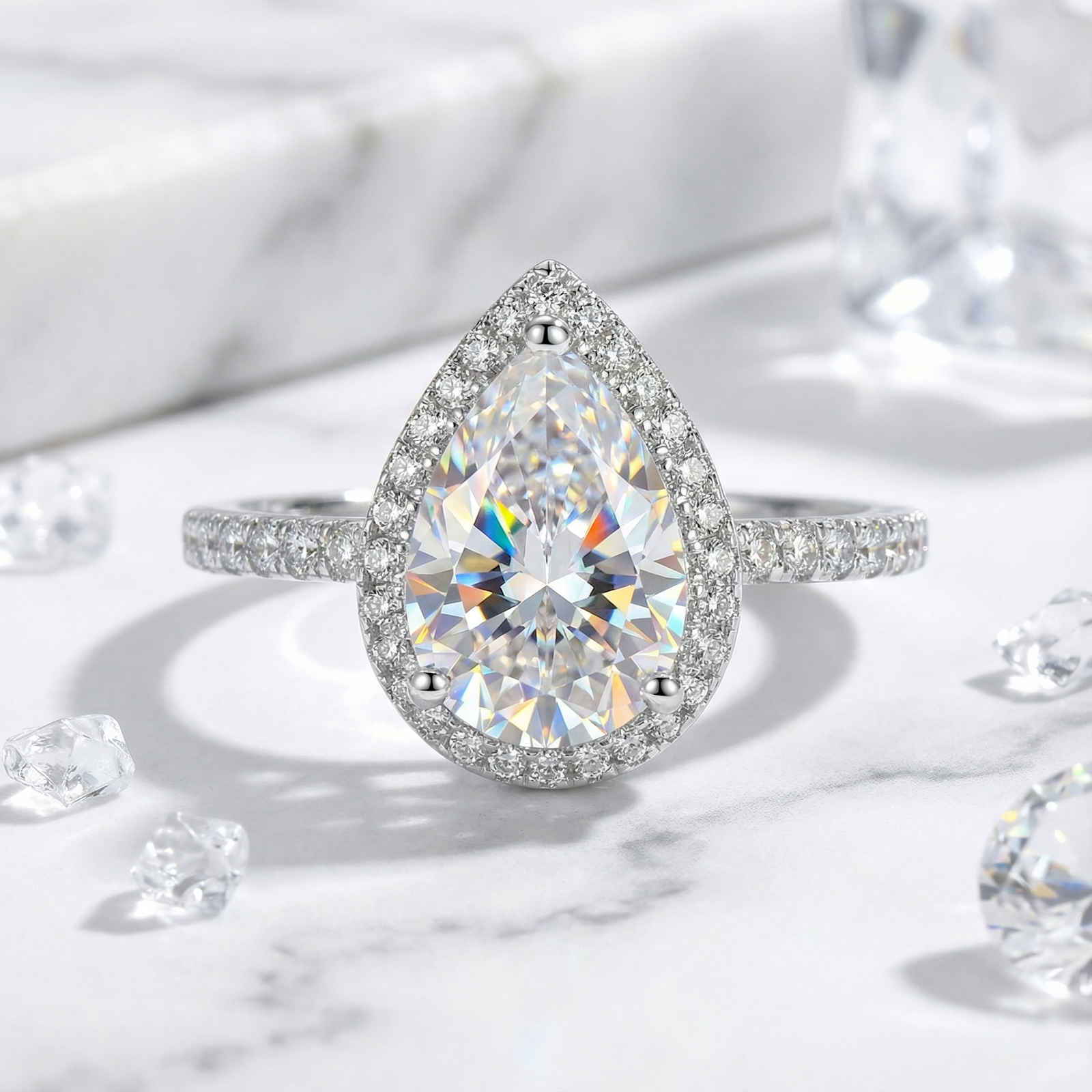 Pear-cut simulated diamond halo ring in S925 sterling silver with a pave band on a marble surface.