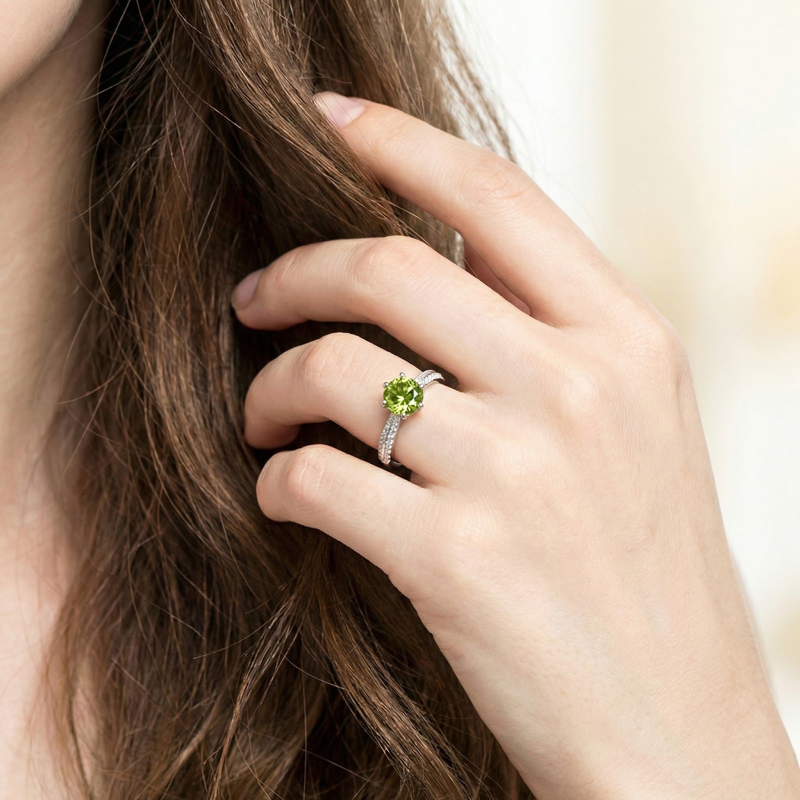 Woman wearing the sterling silver Lysienne milgrain ring with a round simulated peridot stone.