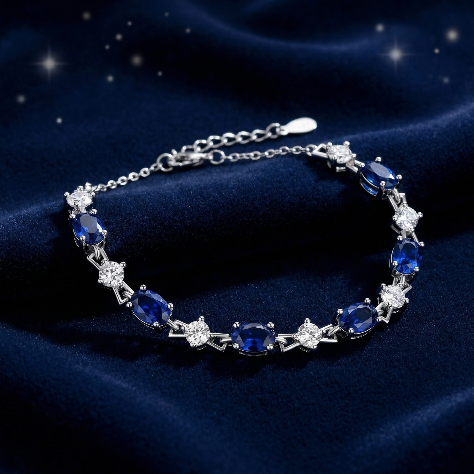 Top view of the Neriselle oval-cut blue simulated sapphire bracelet in silver on a starry blue background.