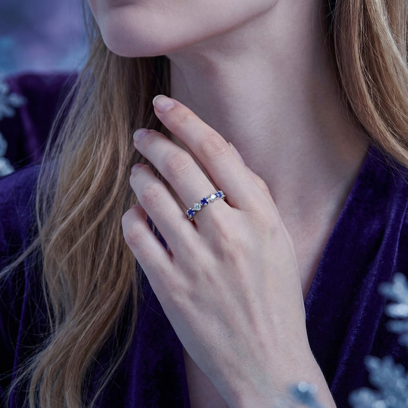 Model wearing the Kyrianne Row sterling silver ring with blue simulated tanzanite and clear stones on her finger.