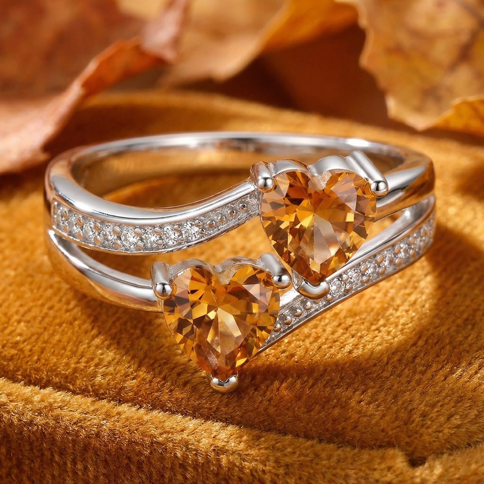 S925 sterling silver bypass ring with two heart-cut honeyed simulated topaz stones on a warm autumn background.