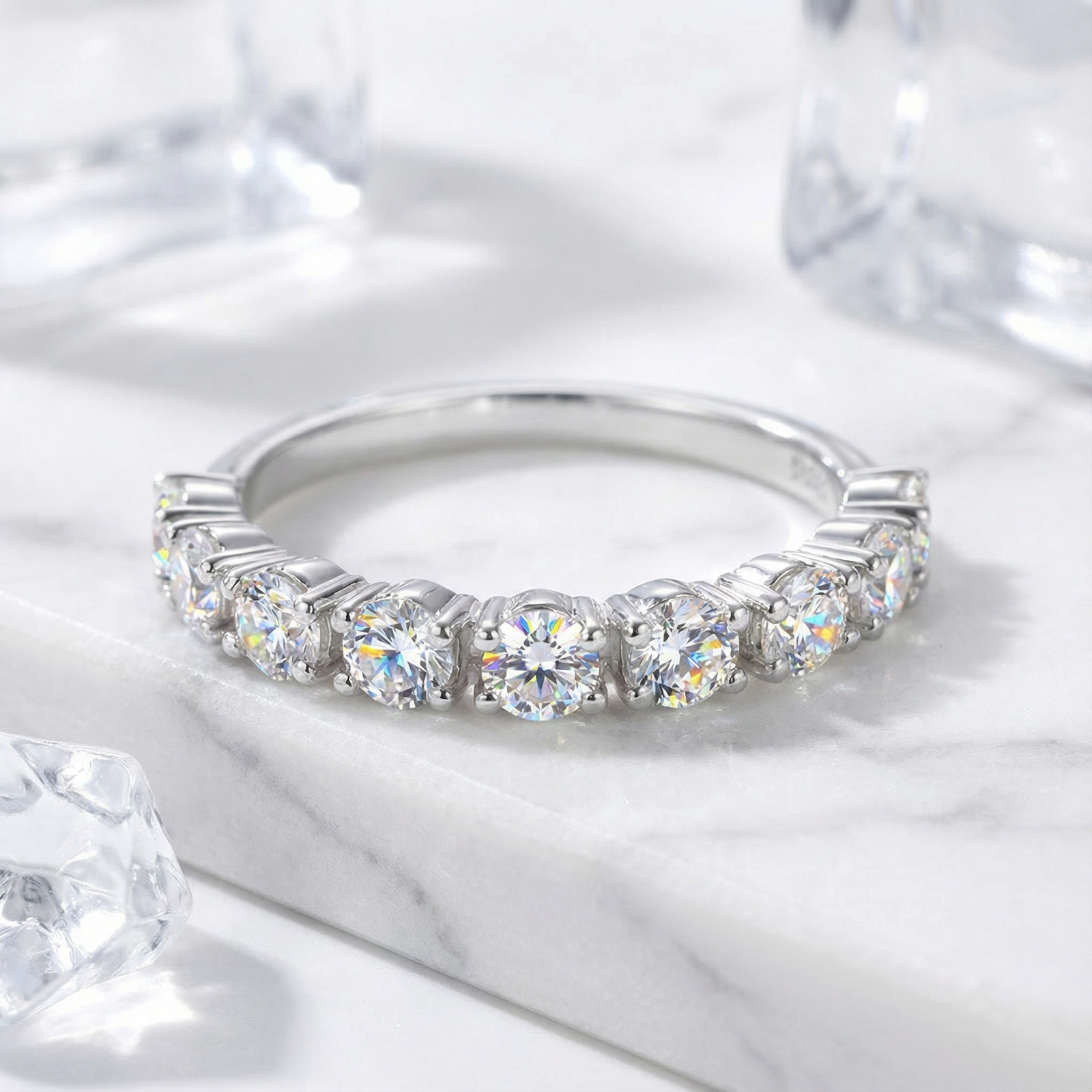 Lucianne S925 sterling silver half-eternity ring with round-cut simulated diamonds on a white marble surface.