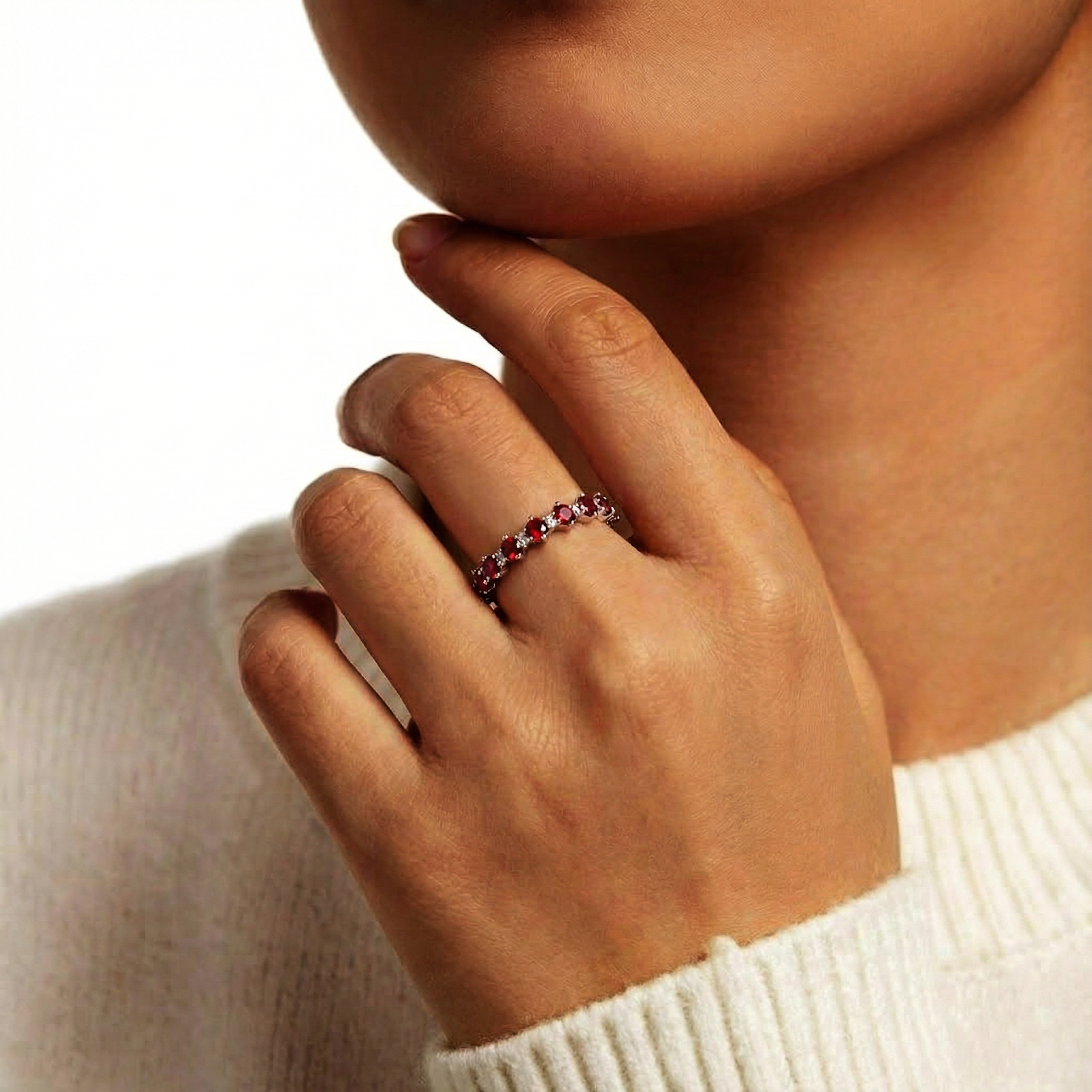 Model's hand wearing the Rubielle S925 sterling silver eternity ring featuring alternating red and clear stones.