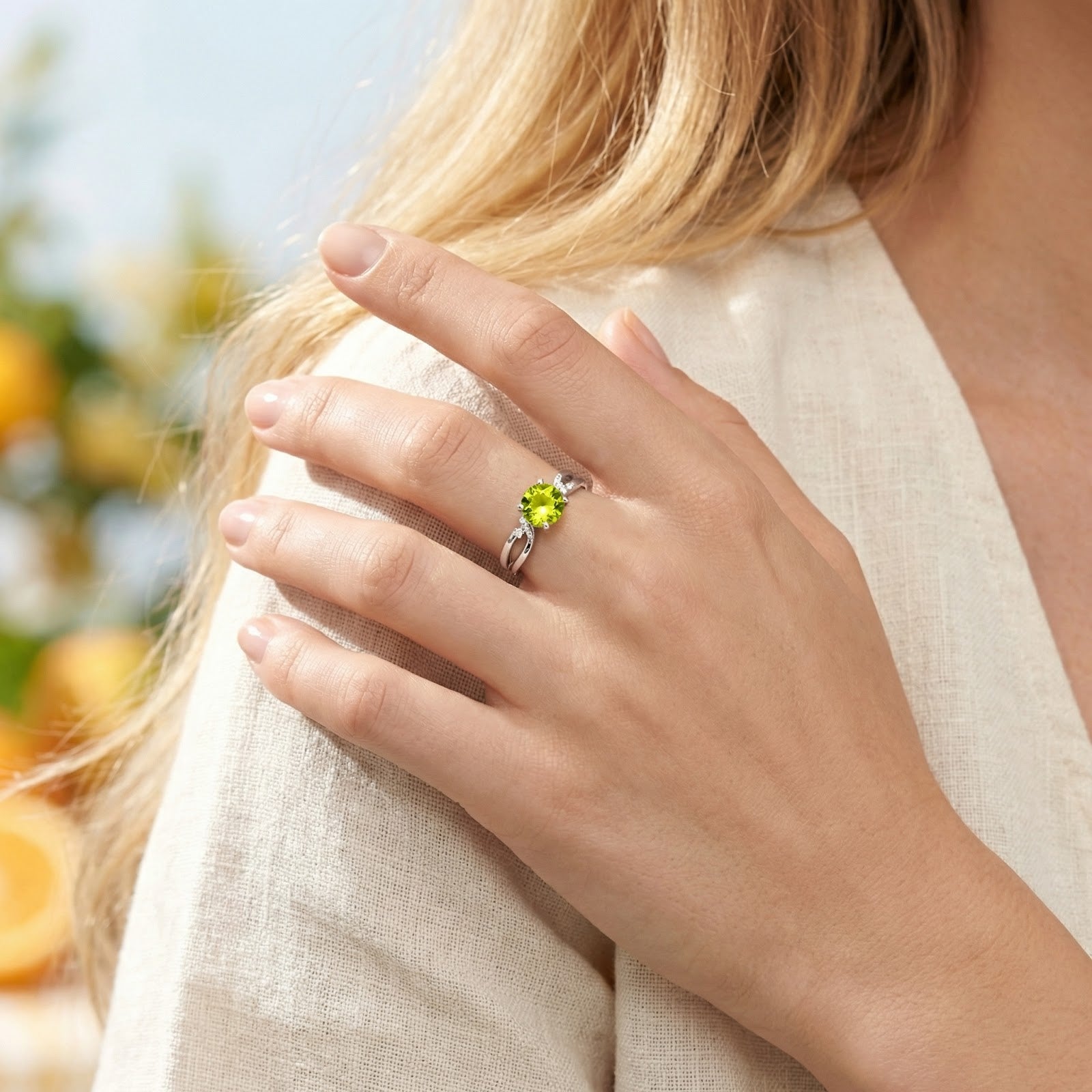 Model wearing the Zelinda S925 sterling silver bypass ring with a round green simulated peridot on her finger.