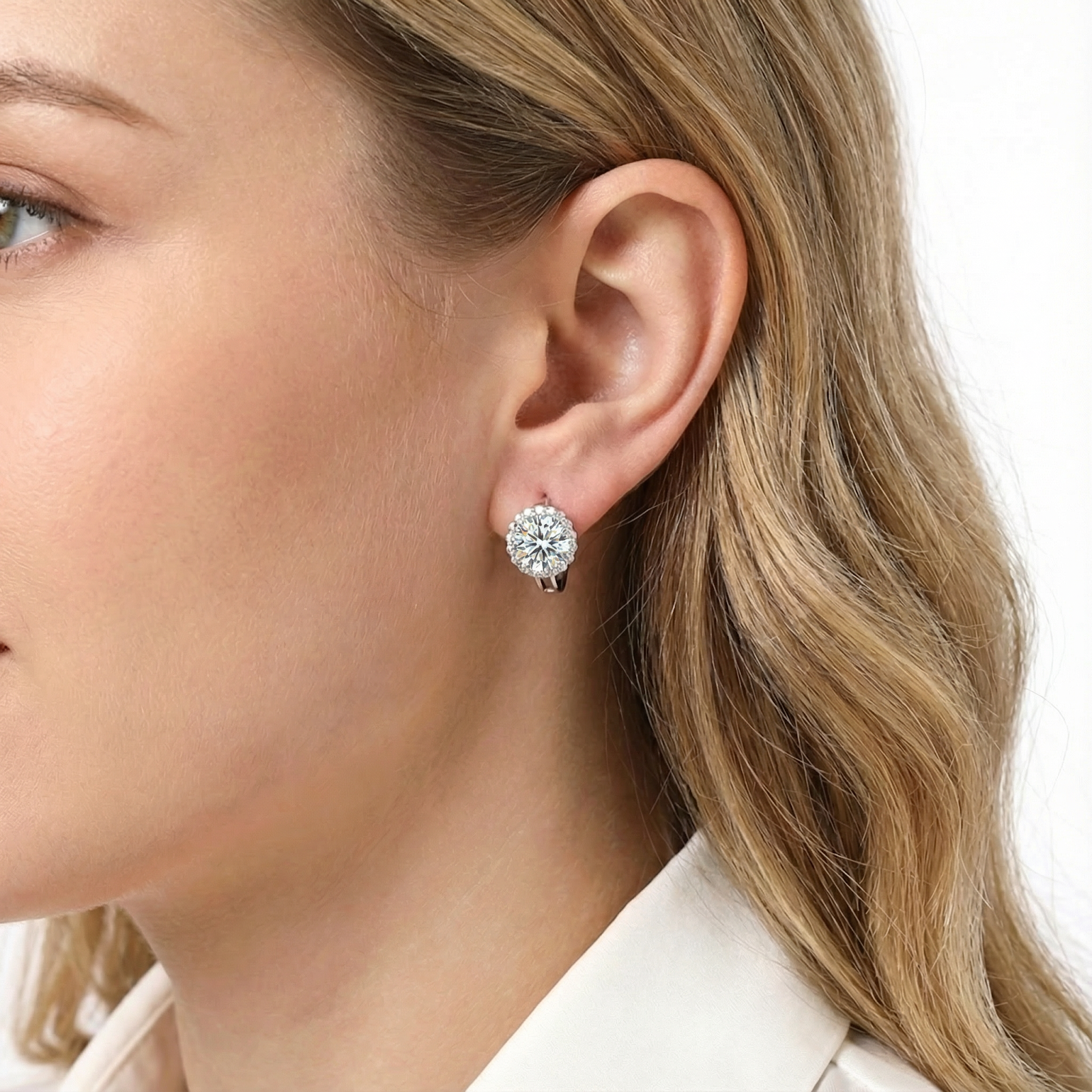 Side profile of a woman wearing a round cut 1CT moissanite halo earring in sterling silver.