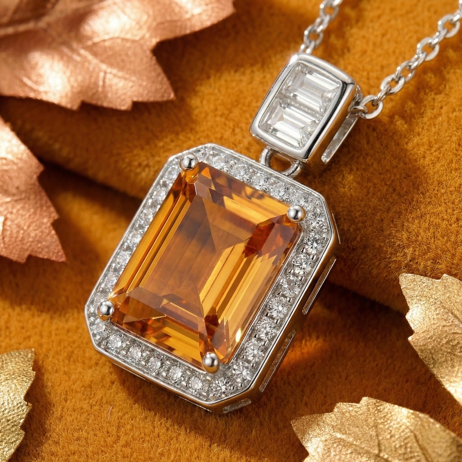 Macro view of an emerald cut simulated topaz pendant in a sterling silver halo setting with baguette accents.