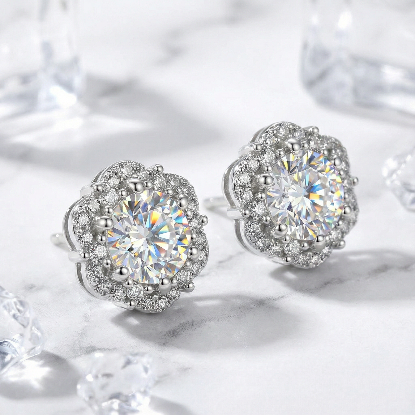 Angled view of Isolde halo stud earrings in S925 sterling silver with round cut simulated diamonds on marble.