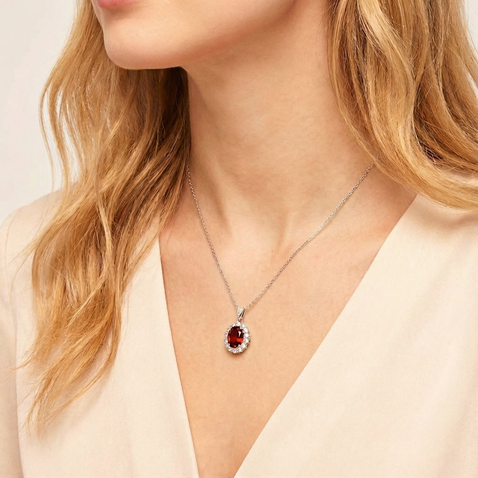 Model wearing the January birthstone oval garnet halo necklace in S925 sterling silver.