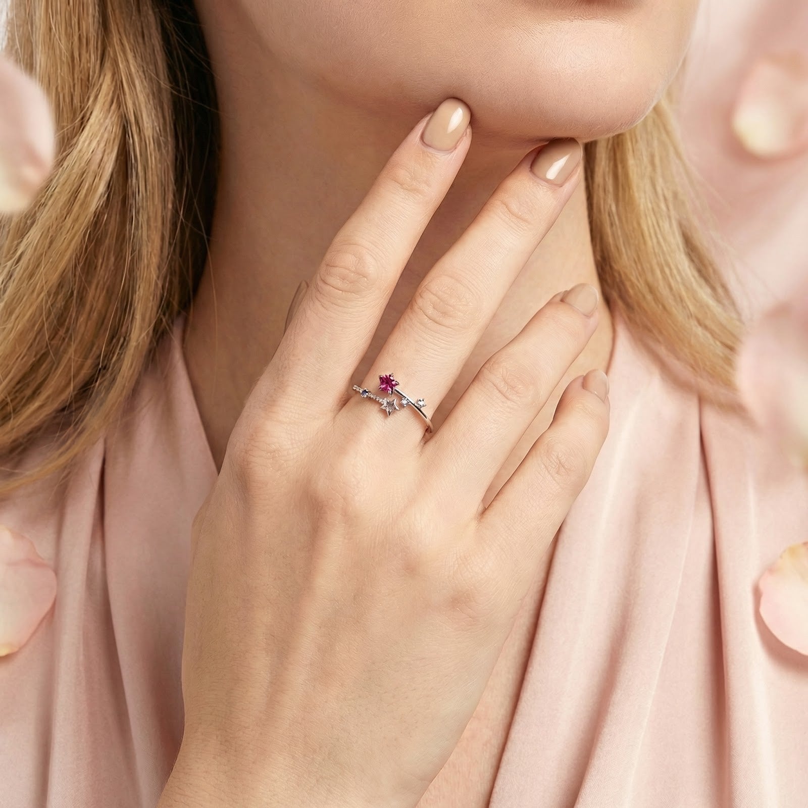 Model wearing the Stellaris bypass ring in sterling silver with vivid raspberry pink tourmaline stones.