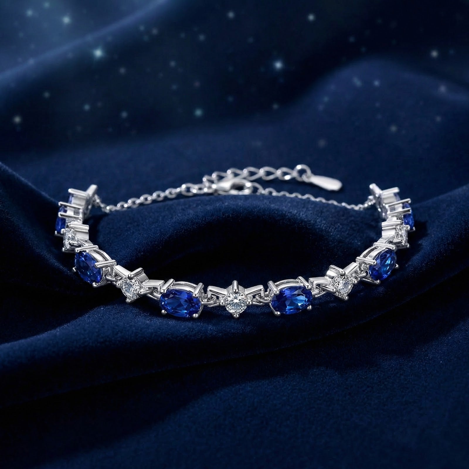 Angled view of the S925 sterling silver bracelet with oval-cut blue simulated sapphires on blue velvet.