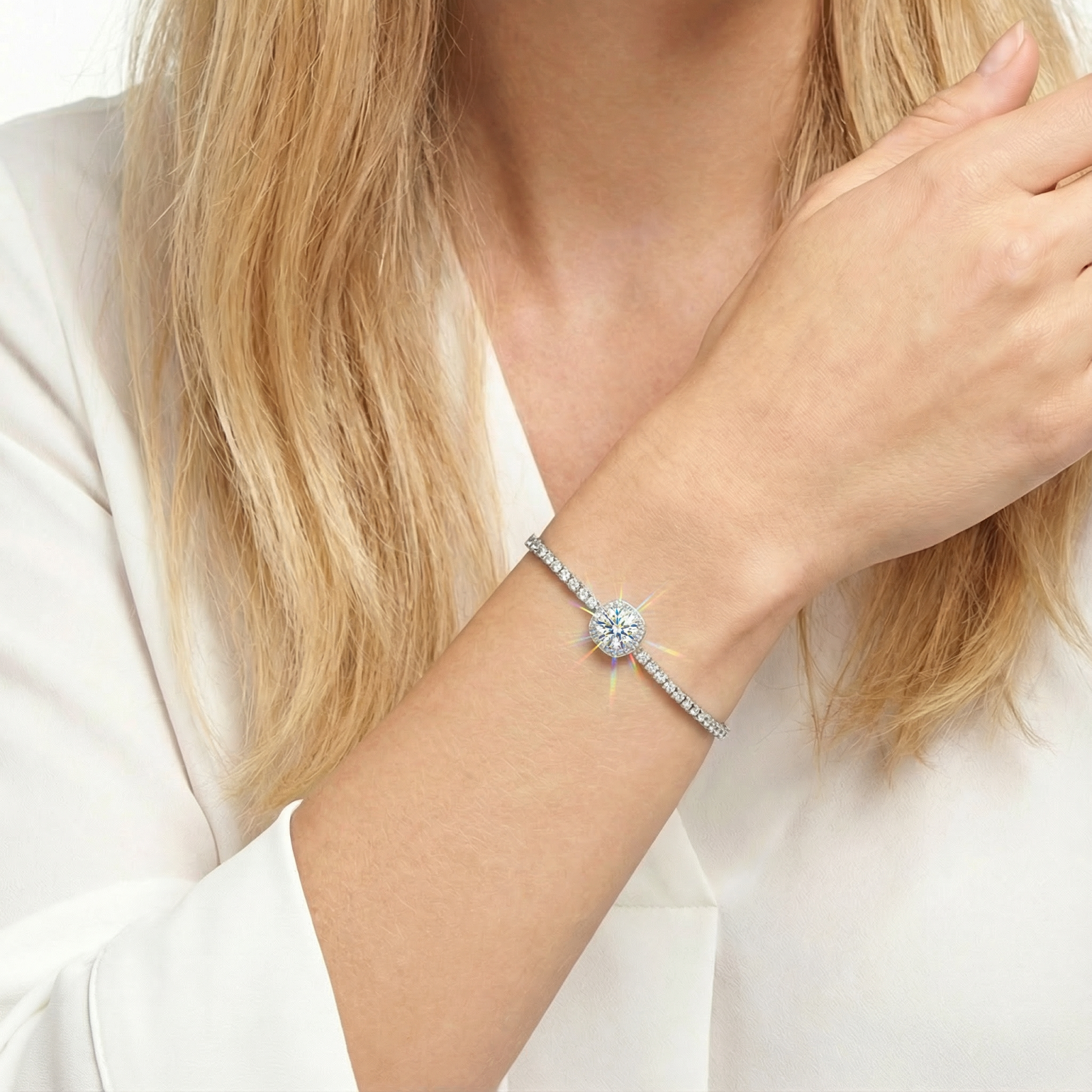 Detailed view of the sterling silver halo bracelet with a round simulated diamond worn on a woman's wrist.
