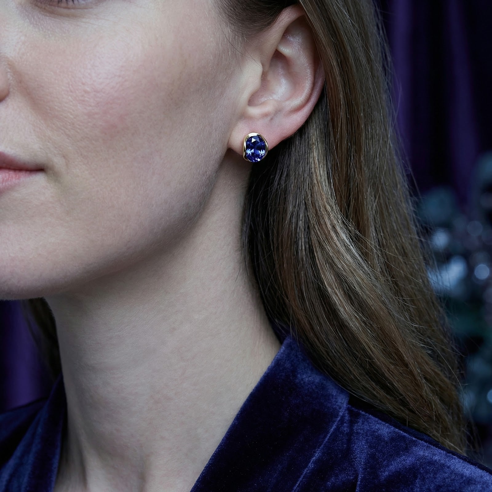 Model wearing the Thalira oval gold vermeil stud earrings with deep violet simulated tanzanite stones.