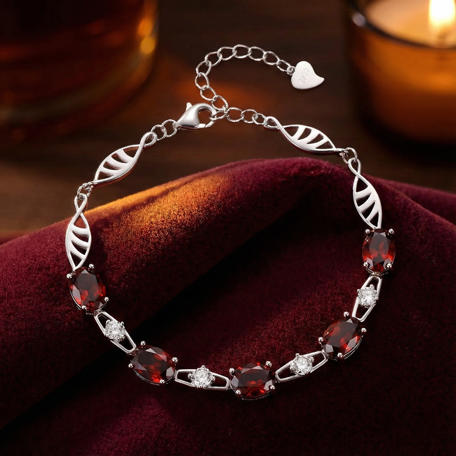 Thalassa helix bracelet in S925 sterling silver with oval cut simulated garnets on red velvet.